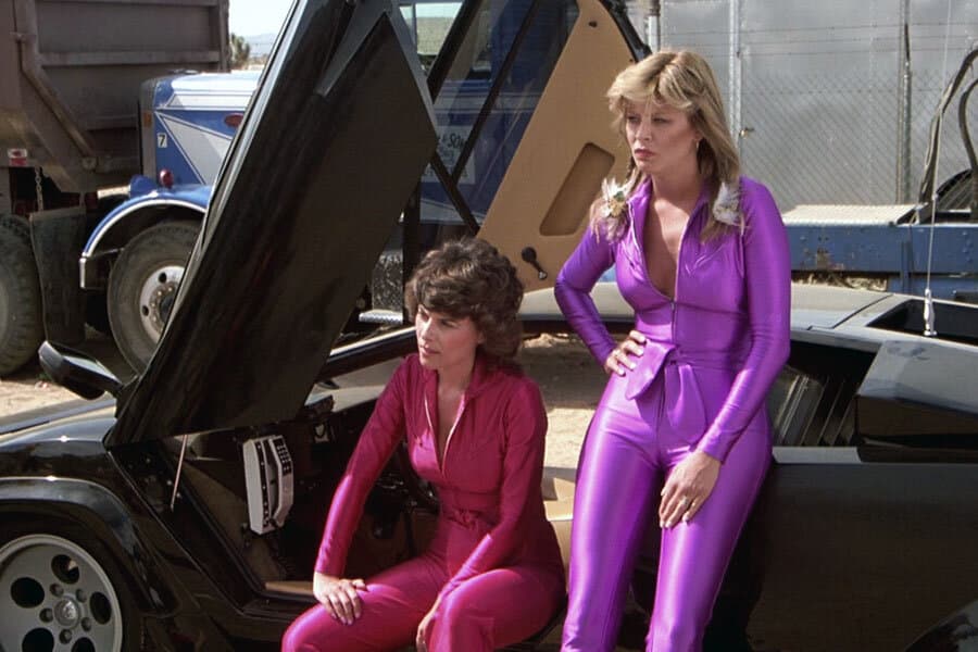 Tara buckman and adrienne barbeau posing near car in jumpsuits
