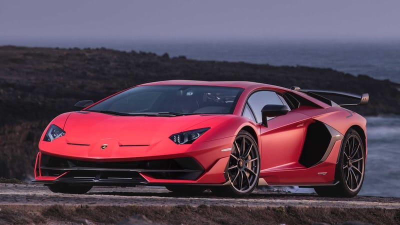 Red Lamborghini Aventador SVJ on road at night
