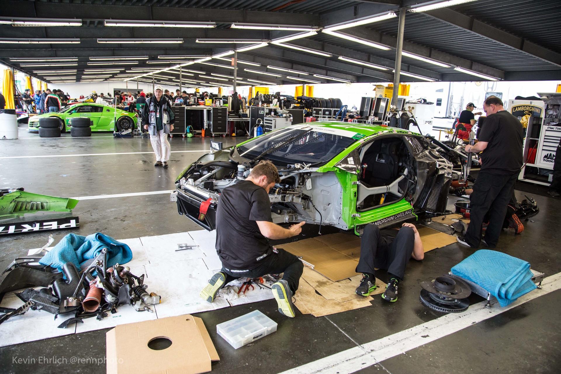 Crew trying to repair damaged corner of green Lamborghini car during 2016 24 Hours of Daytona