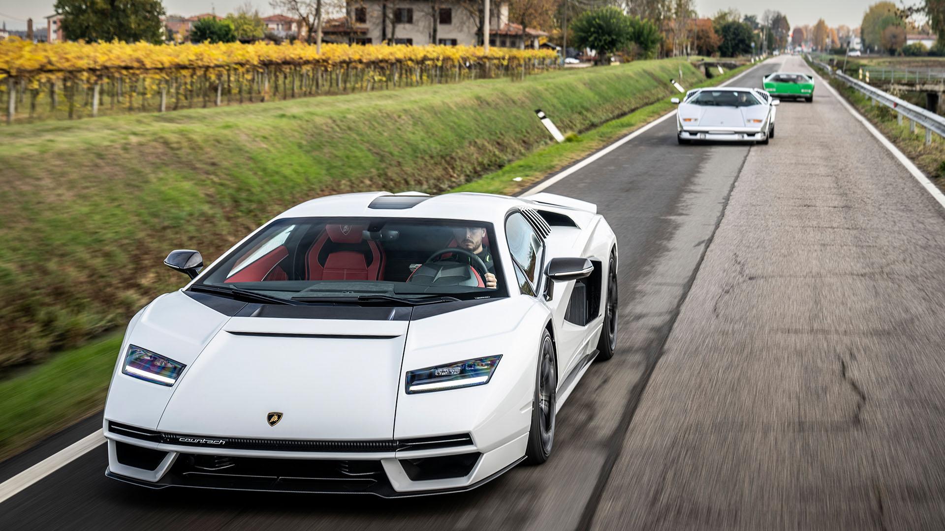 Three generations of Lamborghini Countach driving in formation on a rural road, with the modern LPI 800-4 in the foreground.
