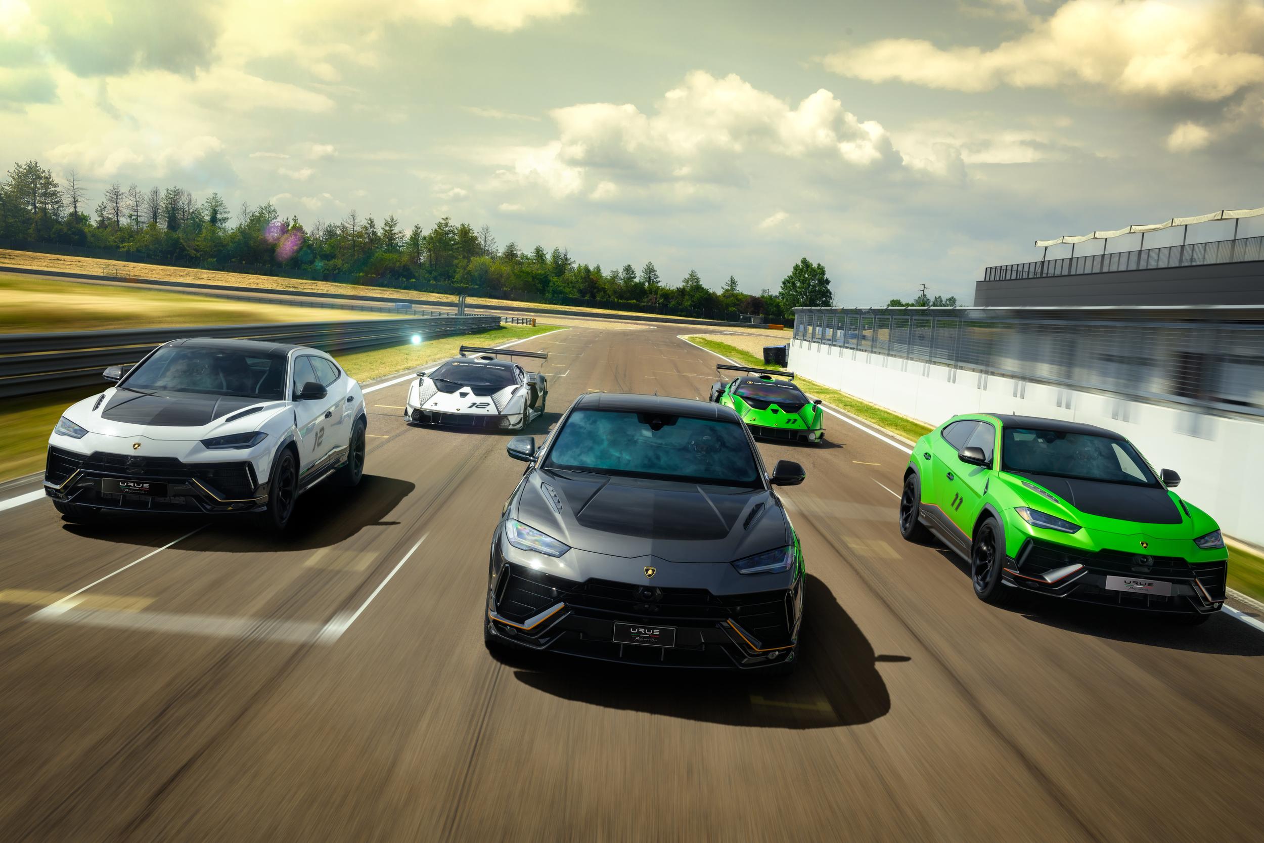 A convoy of multiple Lamborghini Urus Performante models in various colors on a racetrack, with two Essenza SCV12 track cars in the background.
