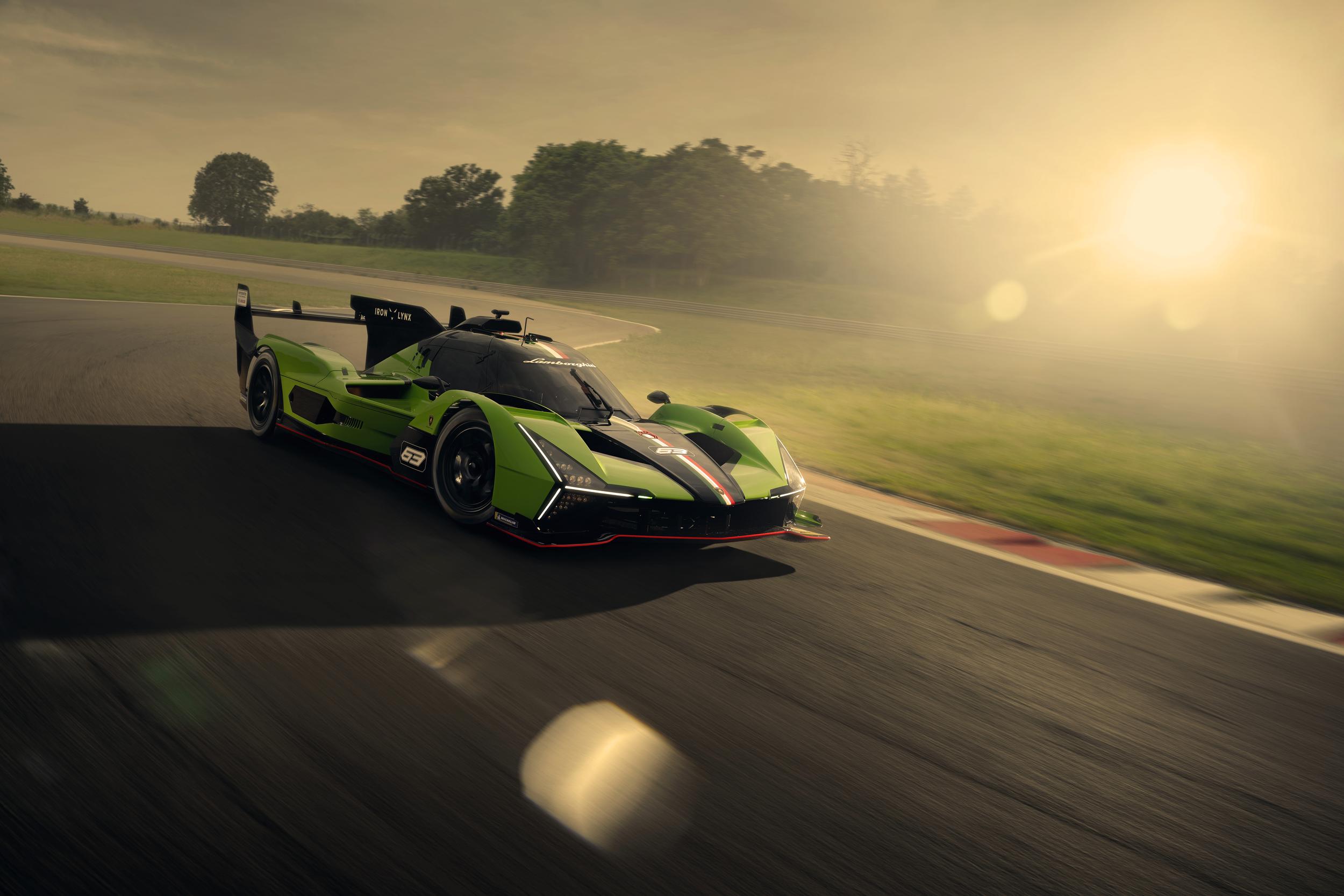 The Lamborghini SC63 LMDh race car in its striking green and black livery on a race track, captured during golden hour.