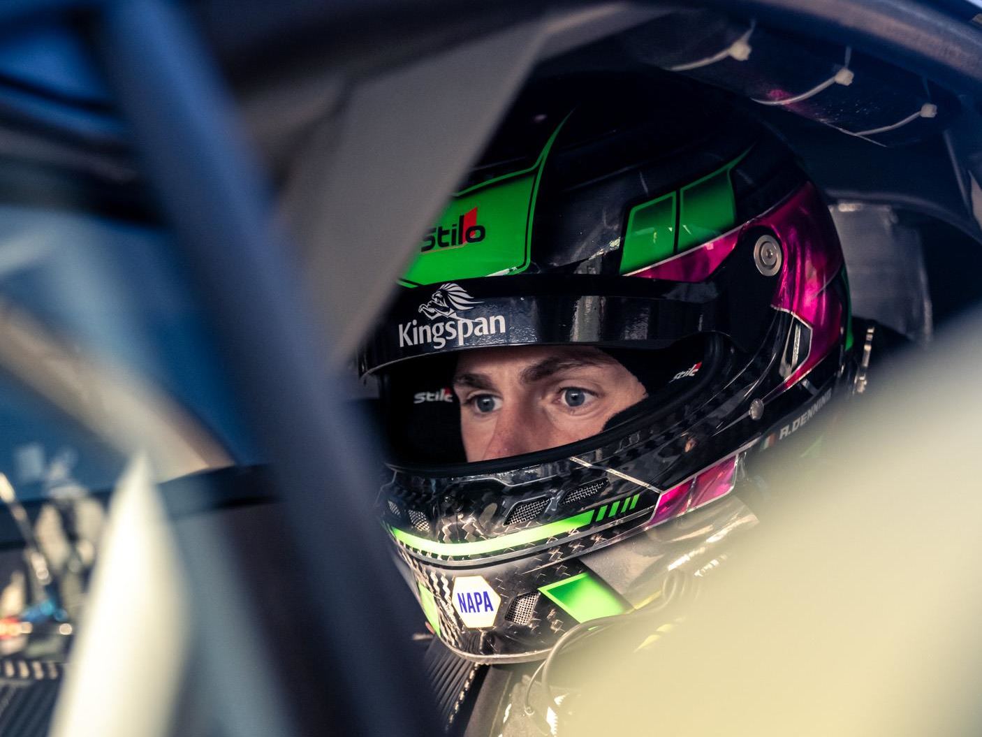 Lamborghini'S Talent Pipeline Delivers: Paul And Michelotto Earn Factory Seats, Cook And Queen Named Junior Winners 13 A close-up shot captures a racing driver's intense gaze from inside their helmet, revealing focus and determination. The helmet features vibrant green and pink accents along with sponsor logos, indica