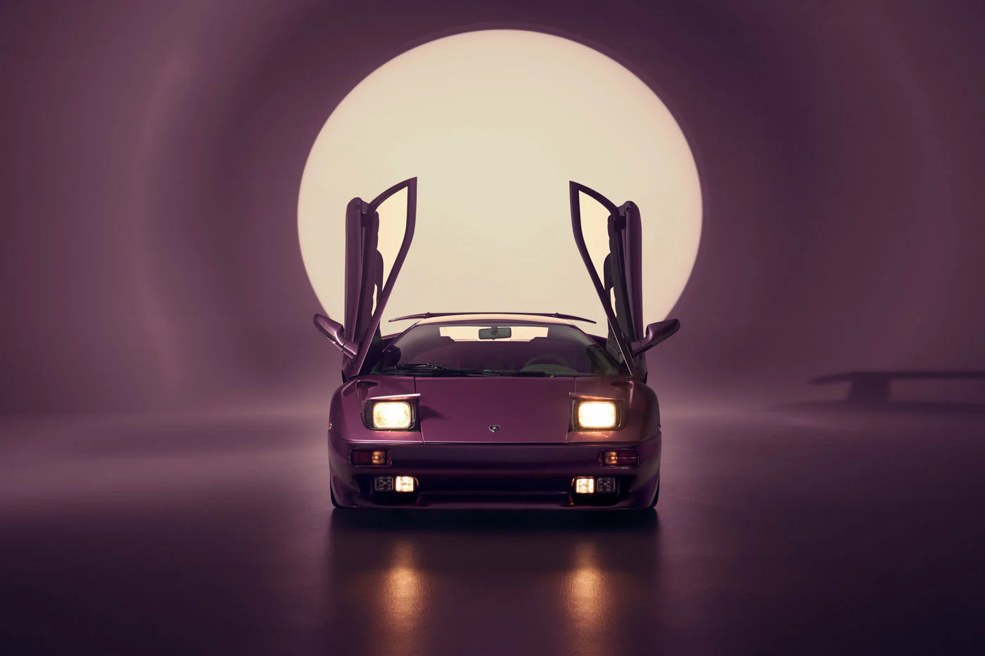 Novitec'S 1,048 Hp Revuelto Program: What It Offers That Lamborghini'S Own Ad Personam Cannot 33 A classic purple lamborghini diablo is presented head-on in a studio, featuring its iconic scissor doors open and pop-up headlights illuminated. A large, soft circular light in the background creates