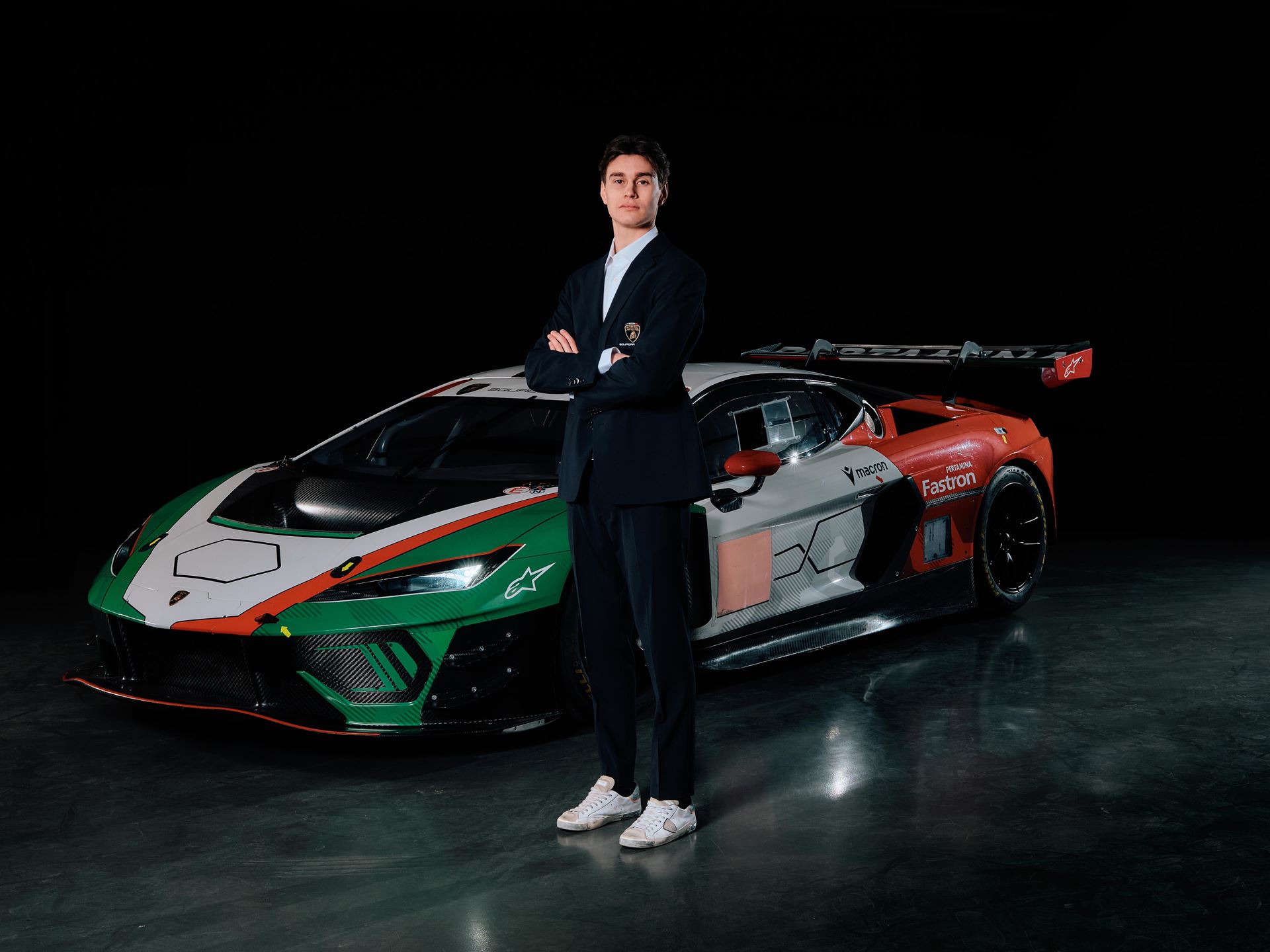 Lamborghini'S Talent Pipeline Delivers: Paul And Michelotto Earn Factory Seats, Cook And Queen Named Junior Winners 5 New lamborghini factory driver standing with arms crossed in front of a lamborghini race car with vibrant green, white, and red racing livery
