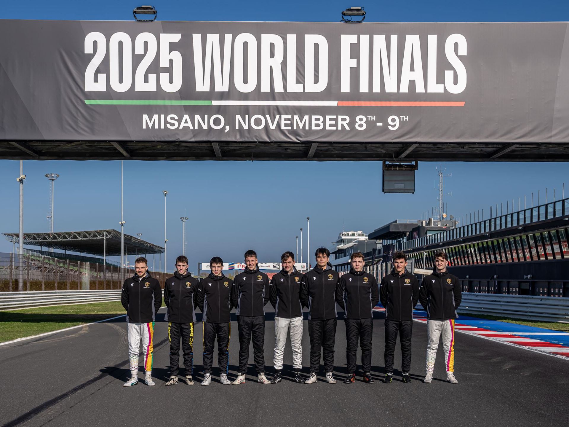 Lamborghini'S Talent Pipeline Delivers: Paul And Michelotto Earn Factory Seats, Cook And Queen Named Junior Winners 9 Group of young drivers standing on the misano race track under the 2025 world finals banner with blue sky background
