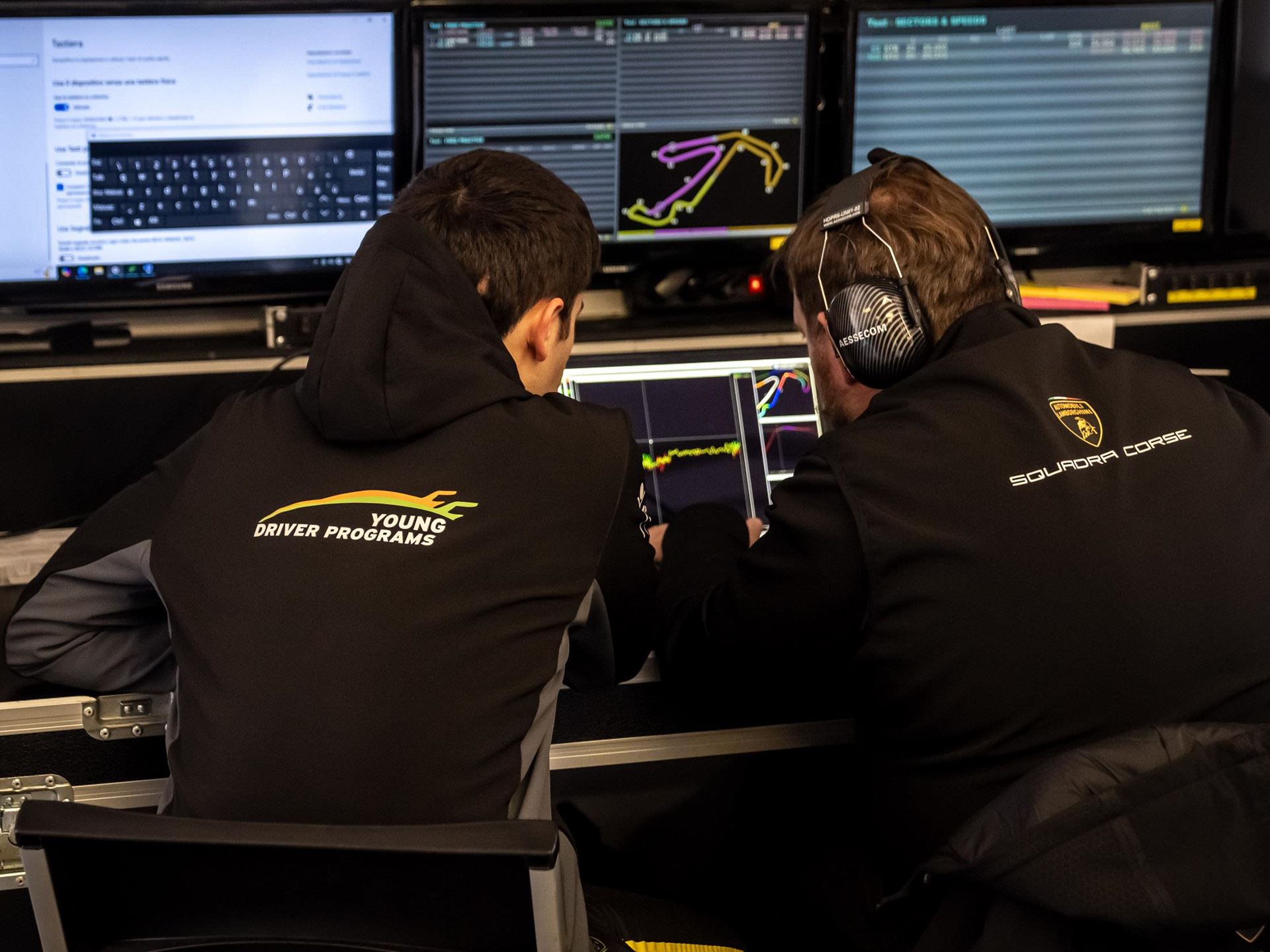 Lamborghini'S Talent Pipeline Delivers: Paul And Michelotto Earn Factory Seats, Cook And Queen Named Junior Winners 3 Two lamborghini squadra corse team members in young driver programs and squadra corse hoodies analyzing telemetry data on multiple computer screens