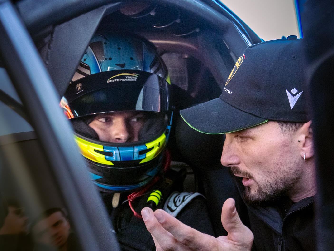 Lamborghini'S Talent Pipeline Delivers: Paul And Michelotto Earn Factory Seats, Cook And Queen Named Junior Winners 11 Lamborghini instructor providing feedback to a young racing driver in the cockpit with young driver programs helmet branding visible