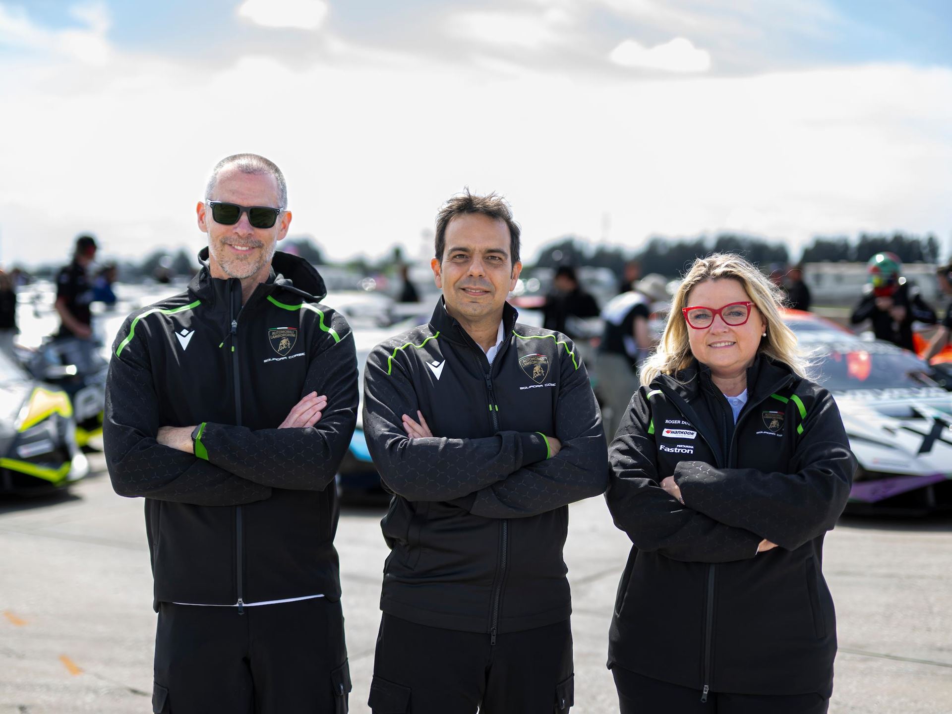 Lamborghini'S New Racing Boss Comes Straight From Ferrari'S Playbook, And The Timing Is No Coincidence 5 Andrea reggiani with regional motorsport coordinators in lamborghini squadra corse jackets on track with huracán race cars