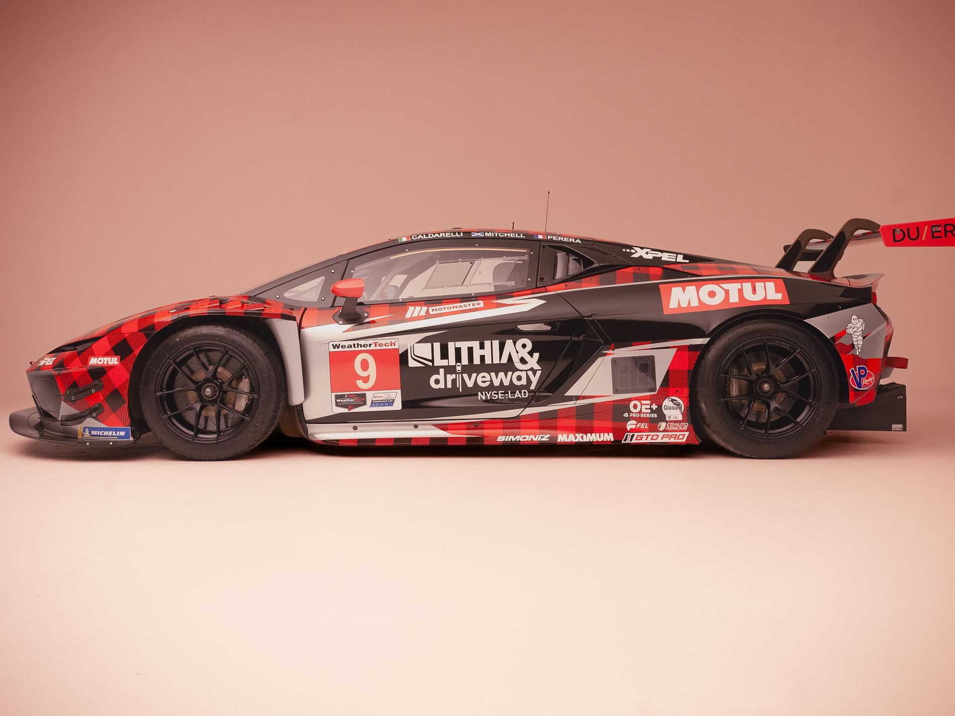 Lamborghini'S First In-House Gt3 Car Faces Brutal Sebring Debut 13 A lamborghini huracan gt3 evo race car, number 9, is presented in a studio, showcasing its full side profile. The car features a distinctive black and red plaid-inspired racing livery with numerous sp