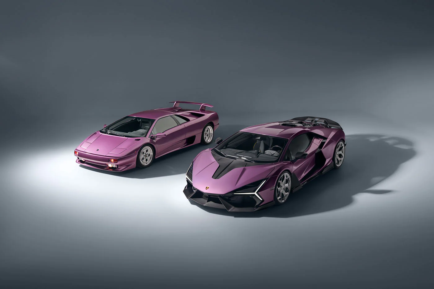 Novitec'S 1,048 Hp Revuelto Program: What It Offers That Lamborghini'S Own Ad Personam Cannot 43 A modern purple lamborghini revuelto and a classic purple lamborghini diablo are displayed side-by-side in a bright grey studio. This comparison shot highlights the evolution of lamborghini's design,