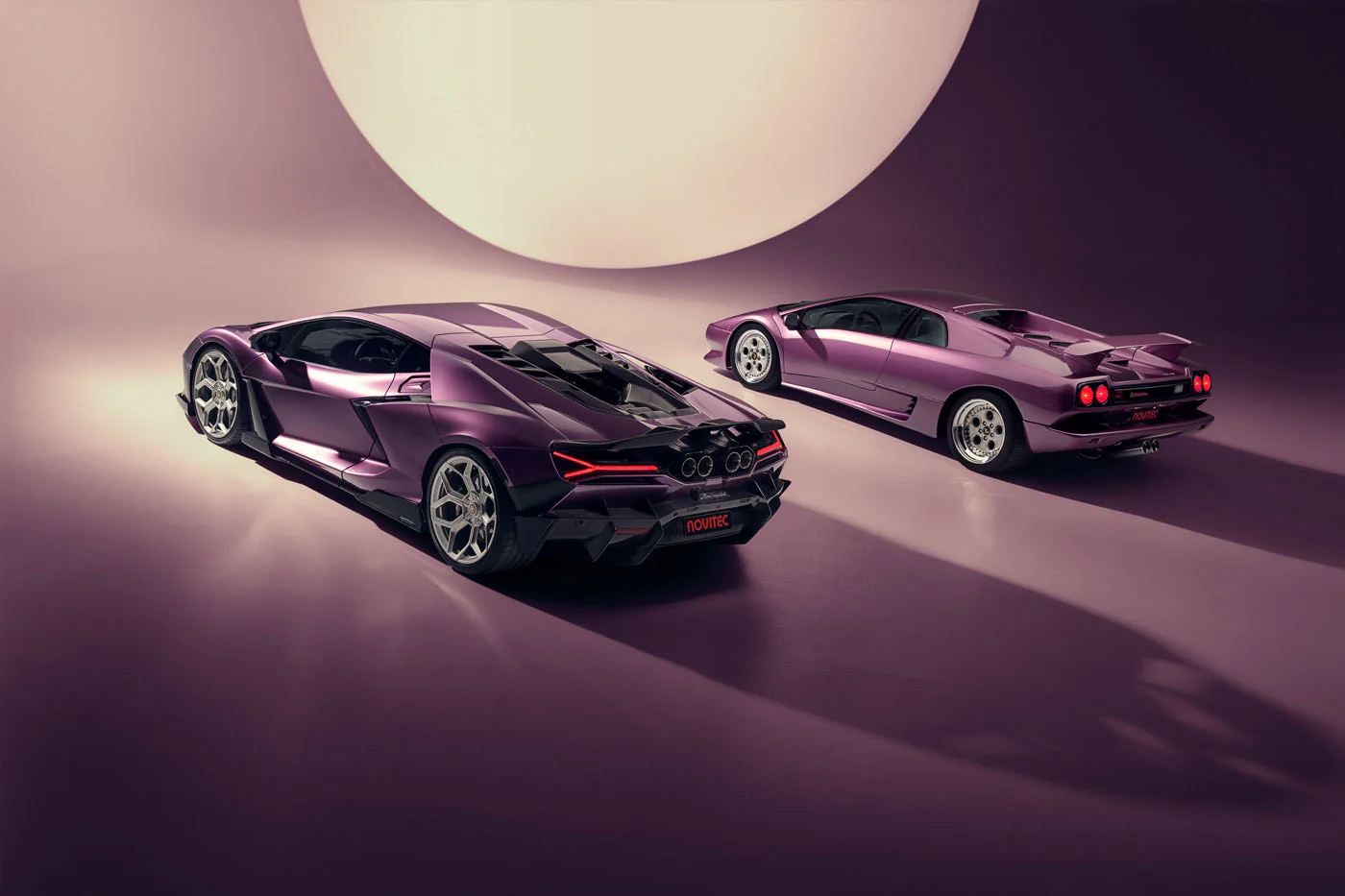 Novitec'S 1,048 Hp Revuelto Program: What It Offers That Lamborghini'S Own Ad Personam Cannot 19 A purple lamborghini revuelto and a purple lamborghini diablo are positioned in a studio, viewed from the rear-three-quarter angle. The image emphasizes the distinct rear designs and aerodynamic philo