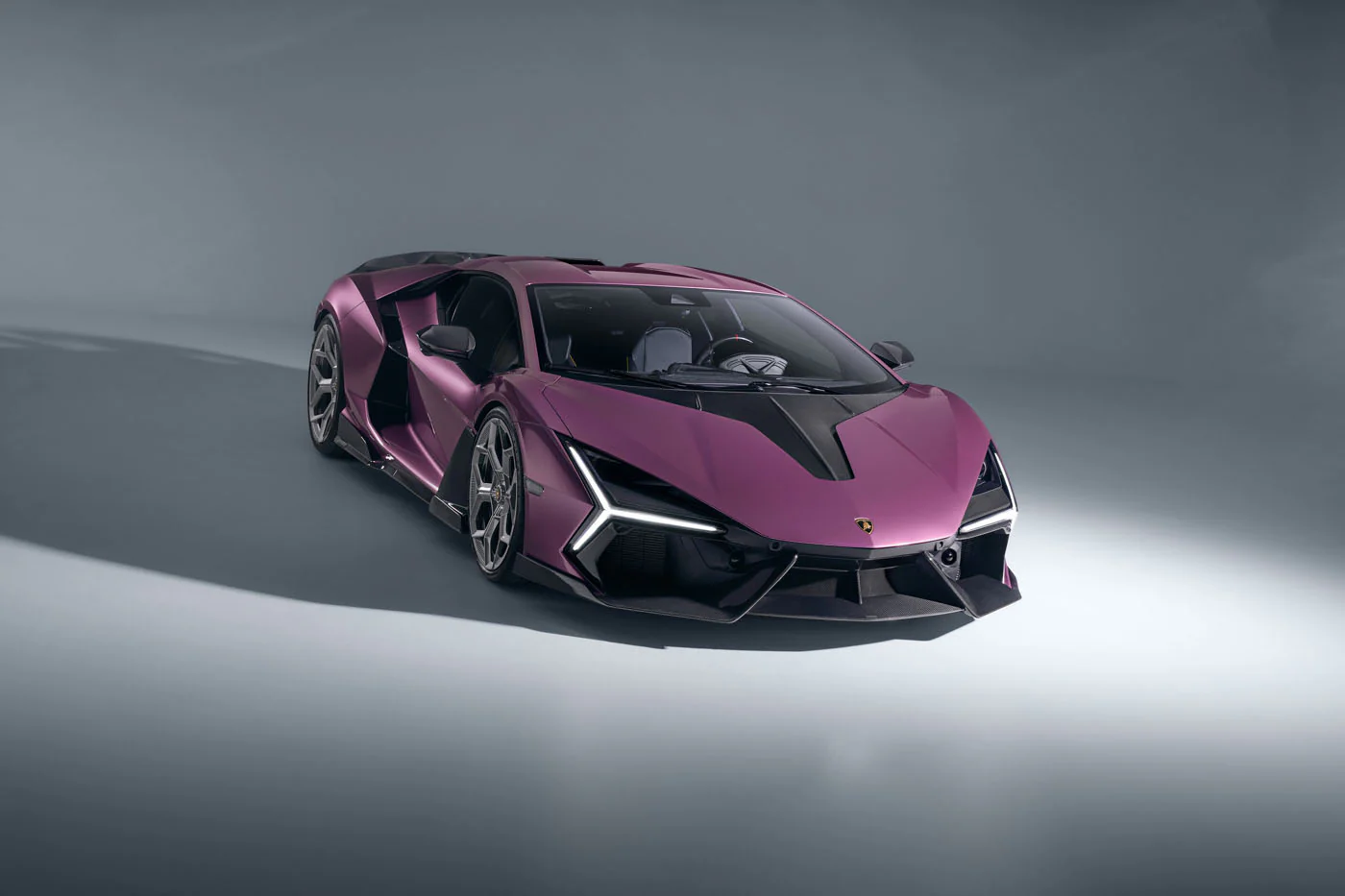 Novitec'S 1,048 Hp Revuelto Program: What It Offers That Lamborghini'S Own Ad Personam Cannot 25 A purple lamborghini revuelto is presented in a studio setting, captured from a front-three-quarter perspective. The image emphasizes the car's sharp, angular design and the intricate details of its f
