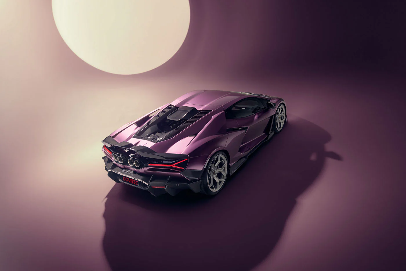 Novitec'S 1,048 Hp Revuelto Program: What It Offers That Lamborghini'S Own Ad Personam Cannot 17 The rear-three-quarter view of a purple lamborghini revuelto in a studio, featuring its distinctive taillights, exposed engine bay, and quad exhaust tips. A large circular light source in the backgrou