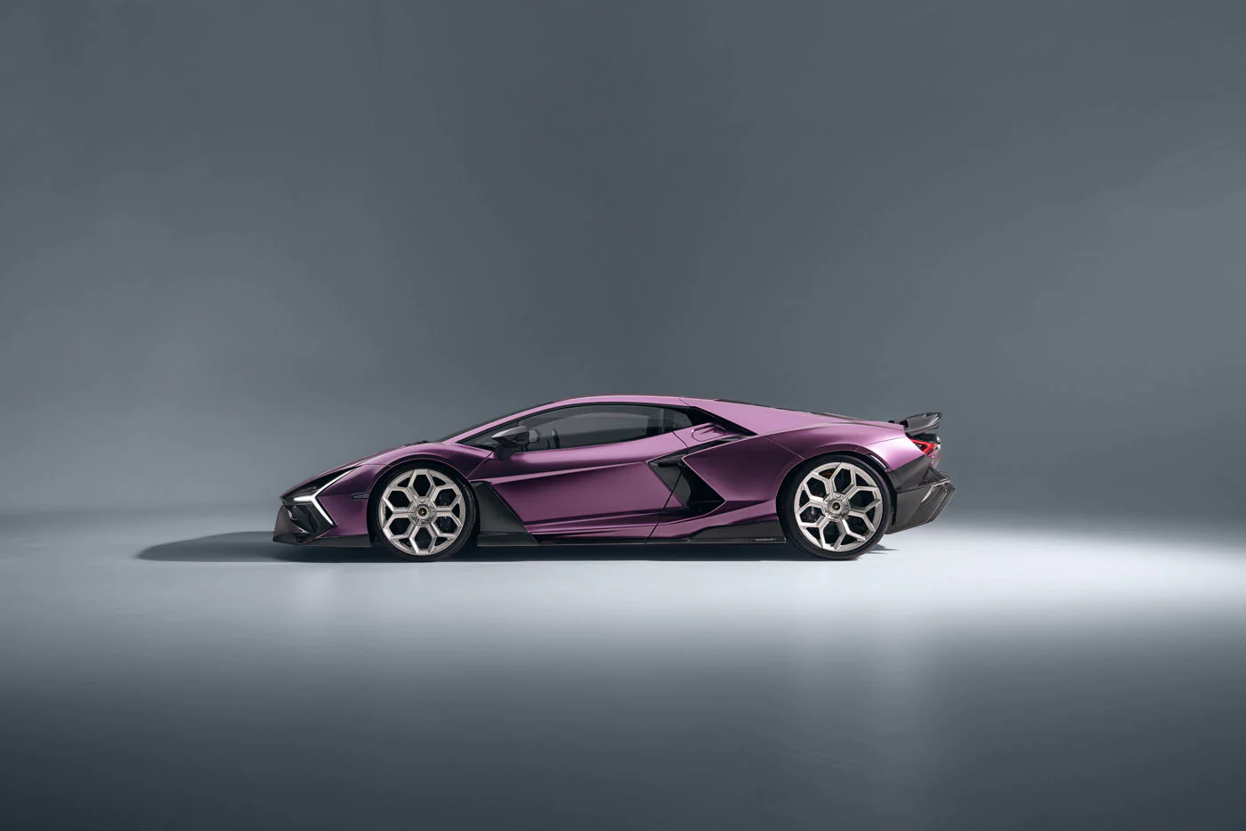 Novitec'S 1,048 Hp Revuelto Program: What It Offers That Lamborghini'S Own Ad Personam Cannot 29 A perfect side profile shot of a purple lamborghini revuelto in a studio, highlighting its elongated silhouette, prominent side air intakes, and distinctive wheel design. The car's low stance and aero