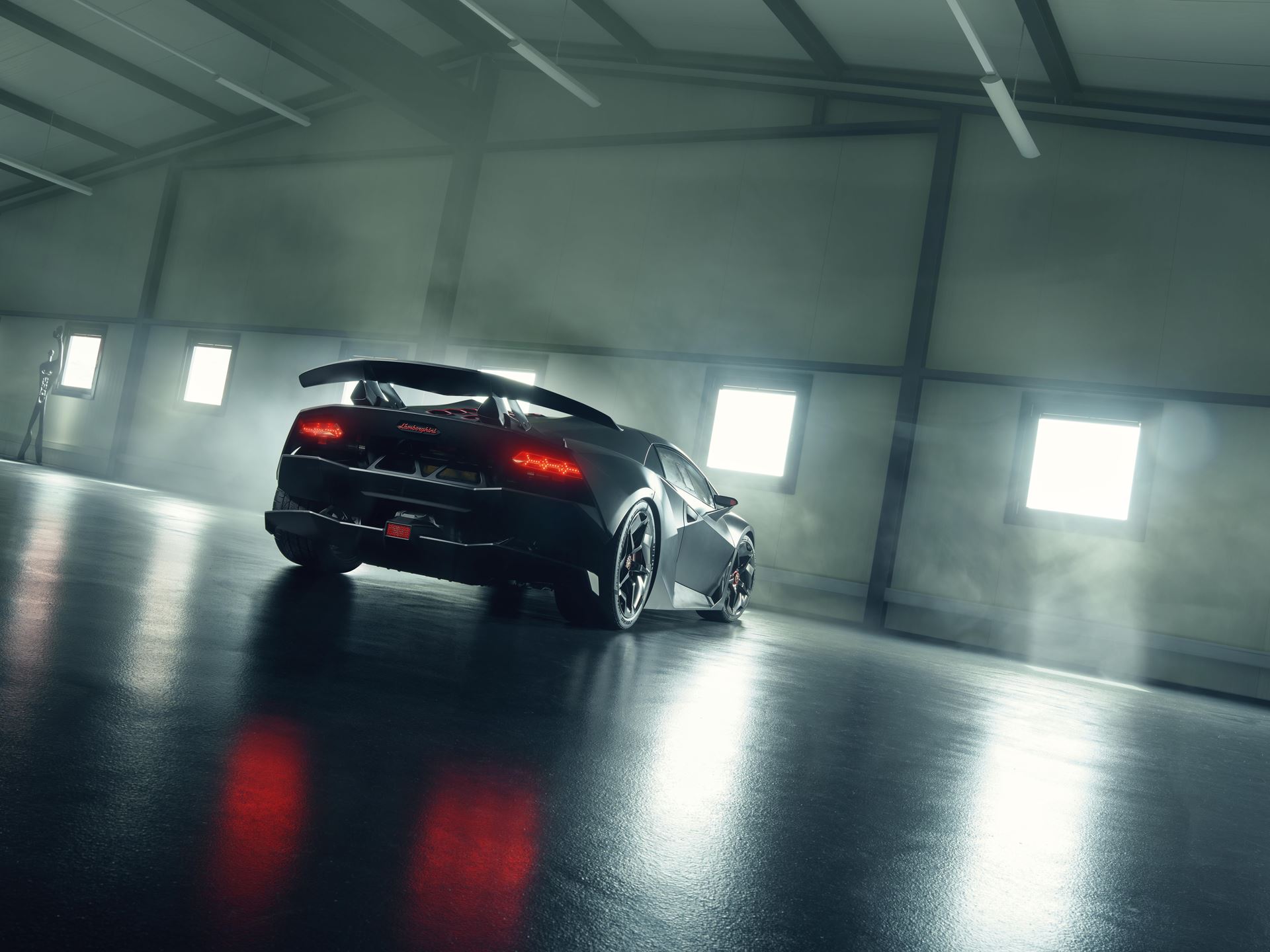 The Sesto Elemento Weighs 999 Kilograms. Some Owners Actually Drive Theirs On Public Roads. 5 Rear three-quarter view of the lamborghini sesto elemento in a misty industrial setting with glowing taillights and prominent rear wing