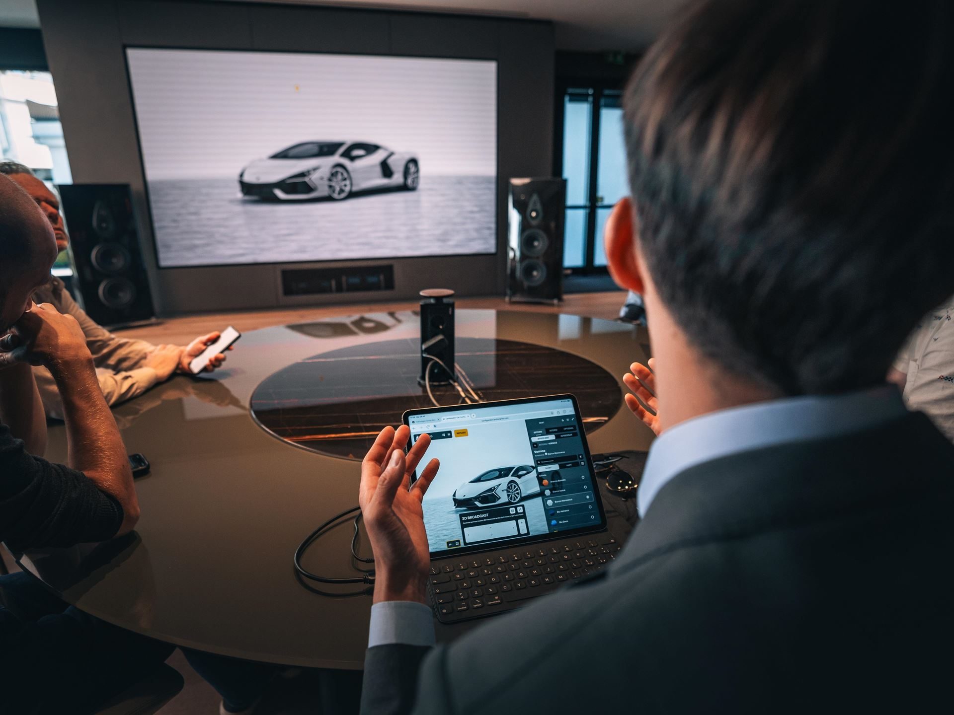 A group consultation session with a Lamborghini customization displayed on a tablet and large screen