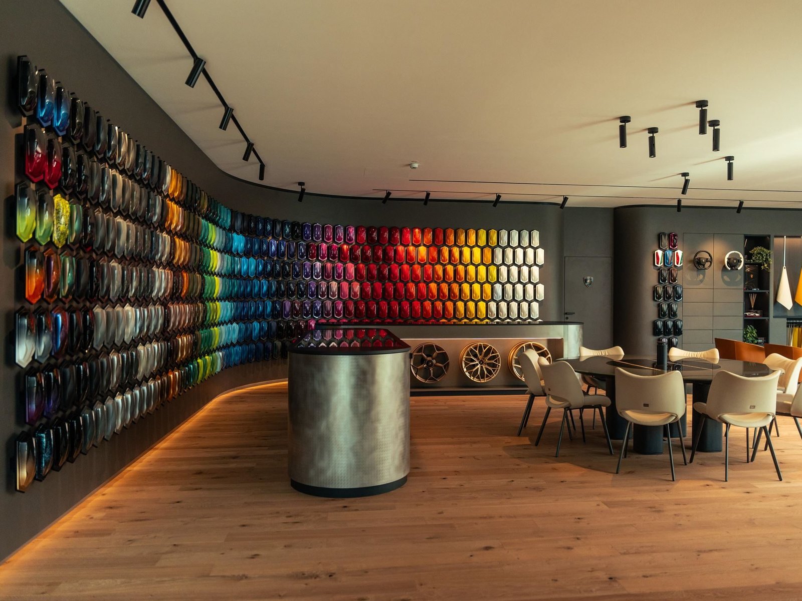 The Lamborghini Ad Personam studio showing a wall of paint samples, wheel options, and a client consultation area