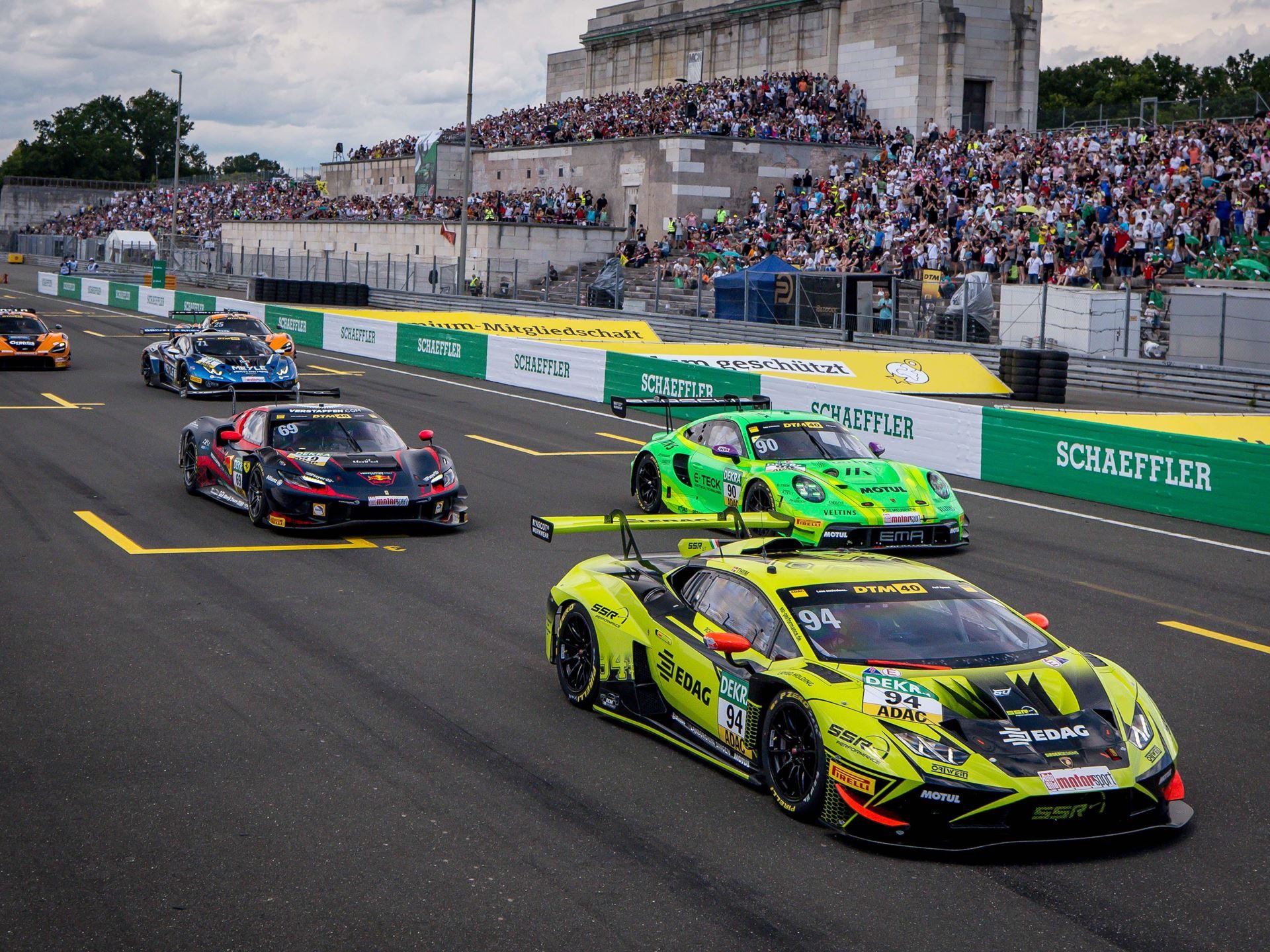 Temerario Gt3 Heads To Paul Ricard For European Debut, But Lamborghini Won'T Show You What It Looks Like 5 Pack of gt race cars including a neon yellow lamborghini huracán gt3 evo number 94 racing on track with grandstands full of spectators
