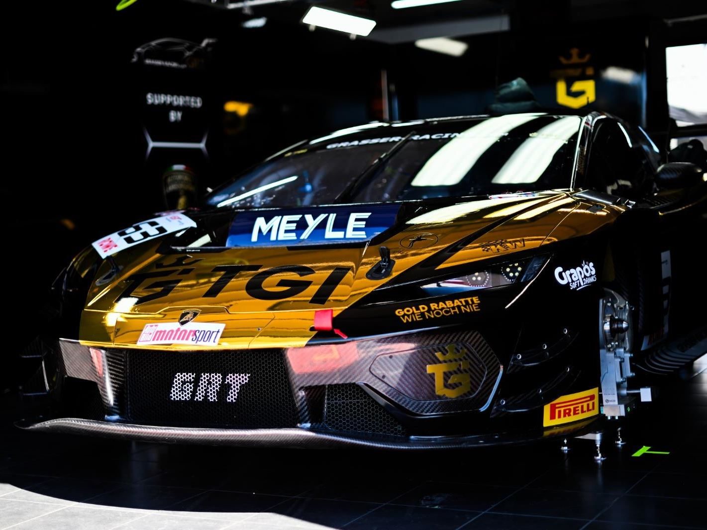 Temerario Gt3 Heads To Paul Ricard For European Debut, But Lamborghini Won'T Show You What It Looks Like 3 Lamborghini huracán gt3 evo race car number 63 in gold and black livery displayed in a garage with jack stand visible