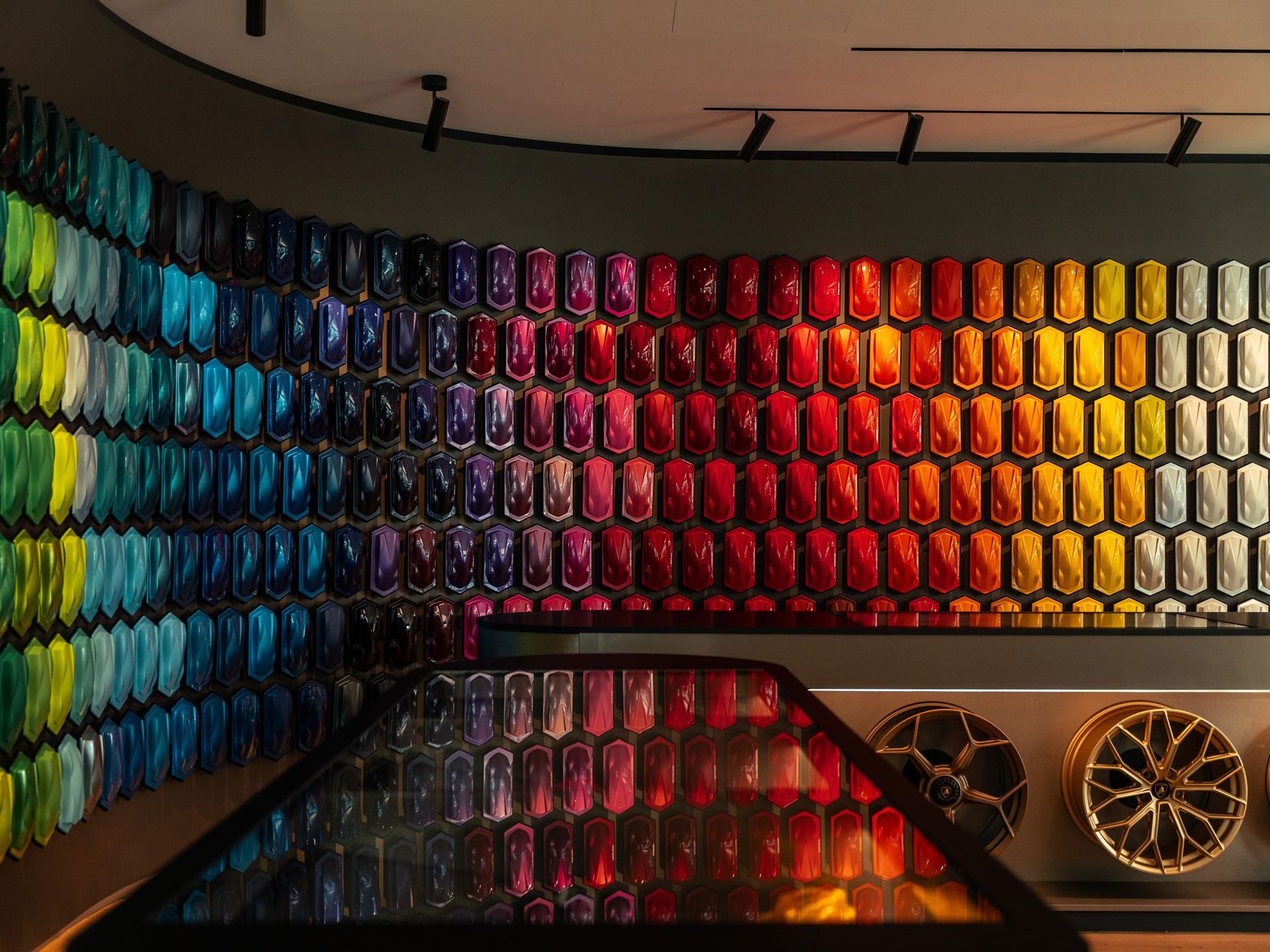 Lamborghini'S Ad Personam Turns 20 With A Miura-Inspired Paint That 96% Of Buyers Should Care About 11 Close-up of hexagonal paint samples arranged in a gradient from blues and greens to reds and yellows on the ad personam studio wall, with wheel displays below