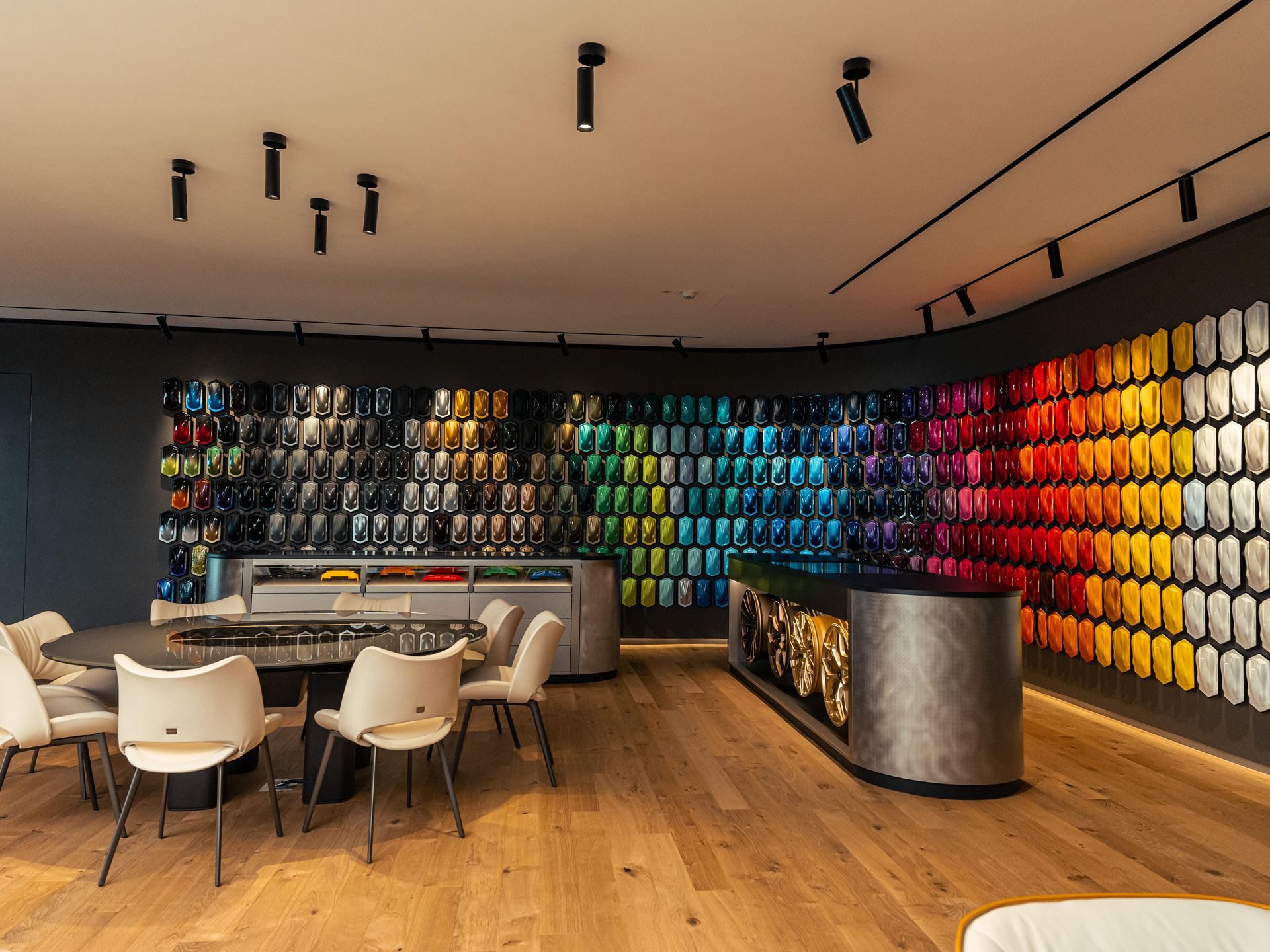 Lamborghini'S Ad Personam Turns 20 With A Miura-Inspired Paint That 96% Of Buyers Should Care About 7 Wide view of the lamborghini ad personam studio with hexagonal paint samples covering the wall, wheels on display, and a central meeting table