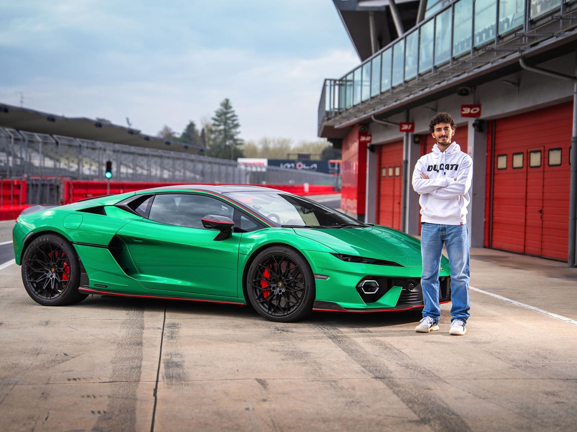 Motogp Champion Pecco Bagnaia Reports The Temerario'S Twin-Turbo V8 Feels Naturally Aspirated At 10,000 Rpm 5 Francesco bagnaia stands beside the vibrant green lamborghini temerario on a racetrack pit lane, showcasing the car's aggressive front fascia, red accents, and black wheels