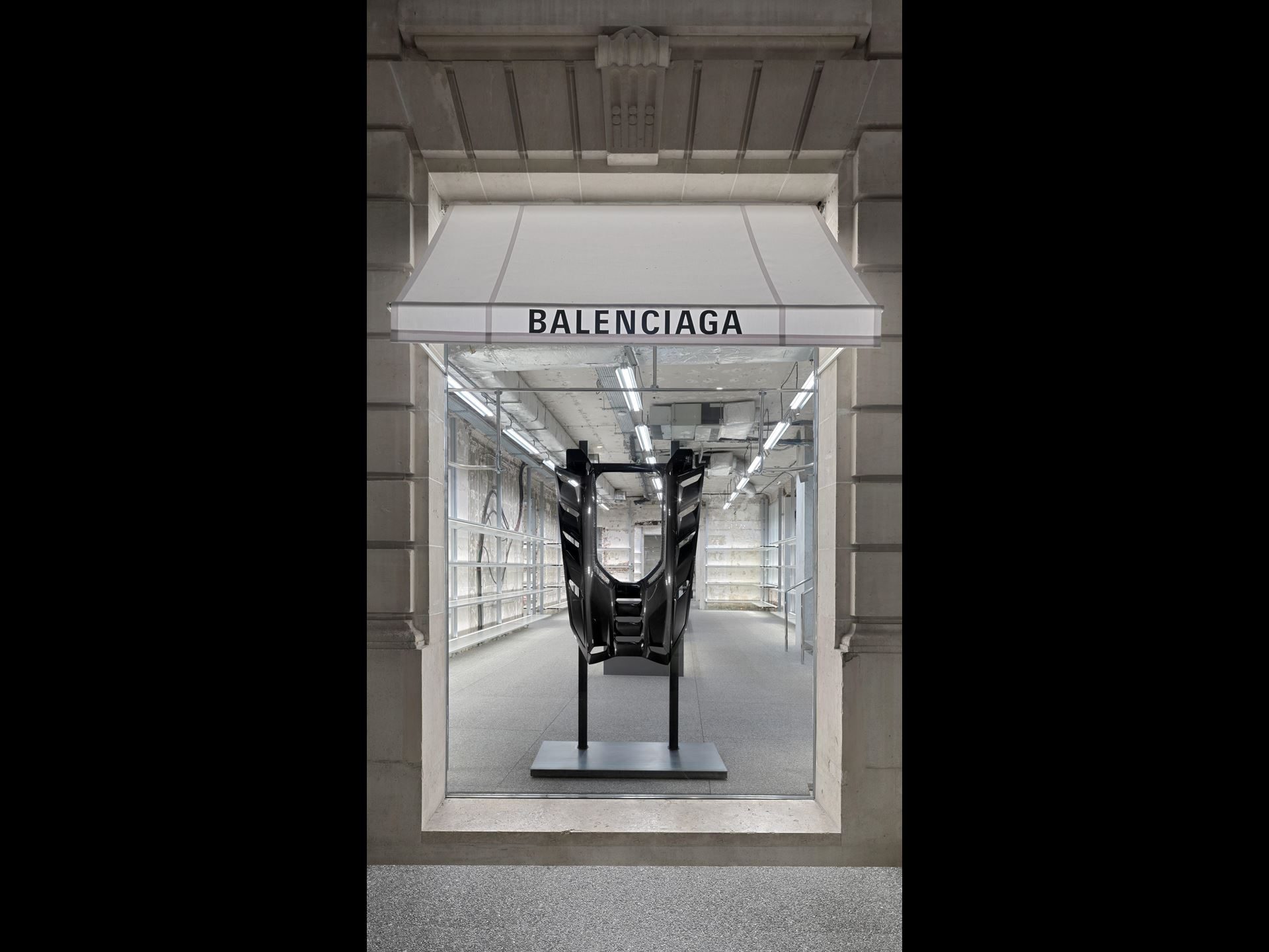 Balenciaga Lamborghini Collaboration Puts Temerario Artwork On The Runway And Graffiti-Wrapped Revueltos Outside Flagships Worldwide 9 Black carbon fiber monocoque chassis of the lamborghini revuelto displayed as art in a balenciaga store window