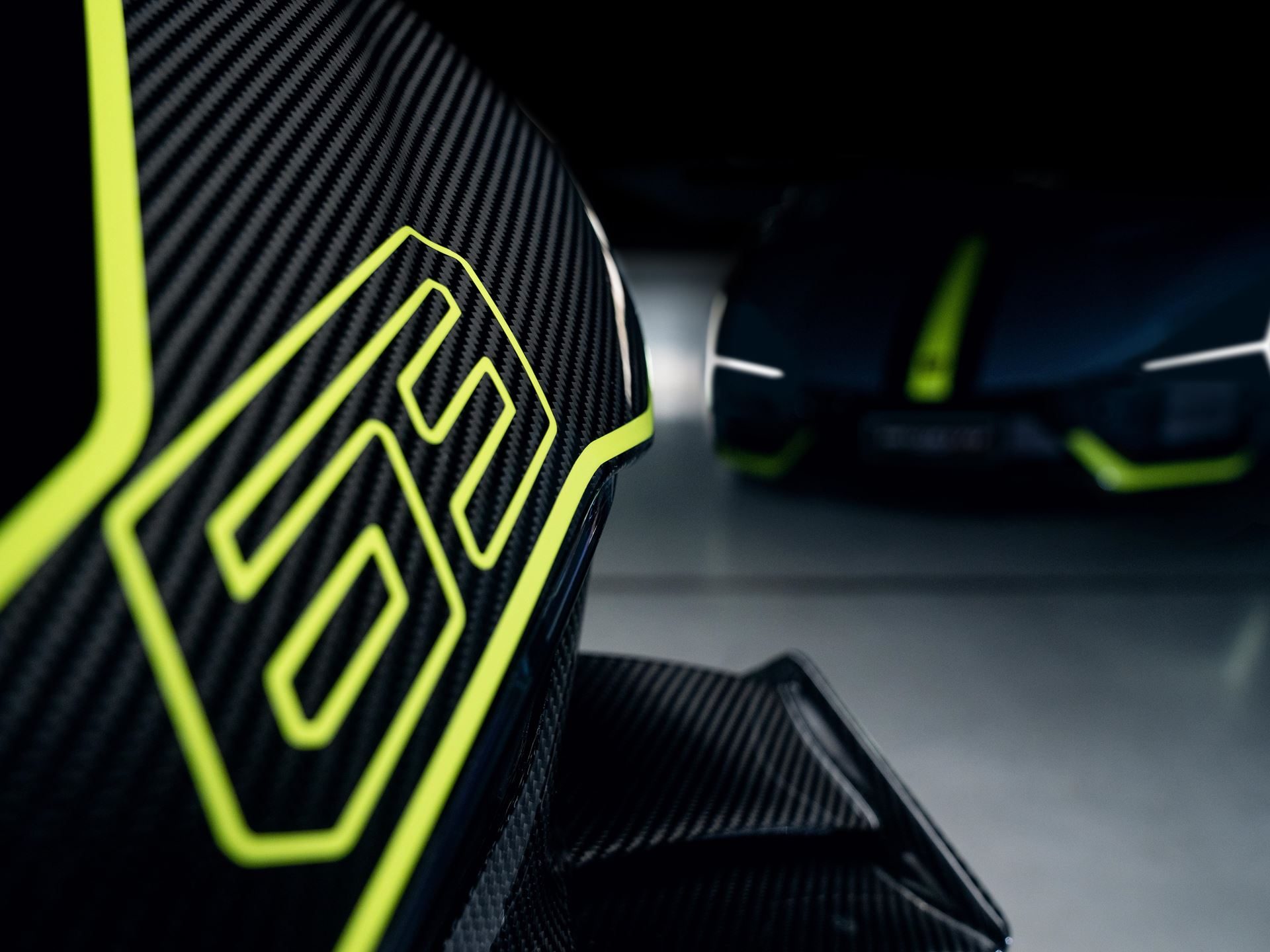 Ducati'S Panigale V4 Lamborghini Lets 63 Revuelto Owners Build A Matching Two-Wheel Garage 5 Close-up of the ducati panigale v4 lamborghini's carbon fiber bodywork with verde scandal '63' graphic and the blurred revuelto in the background