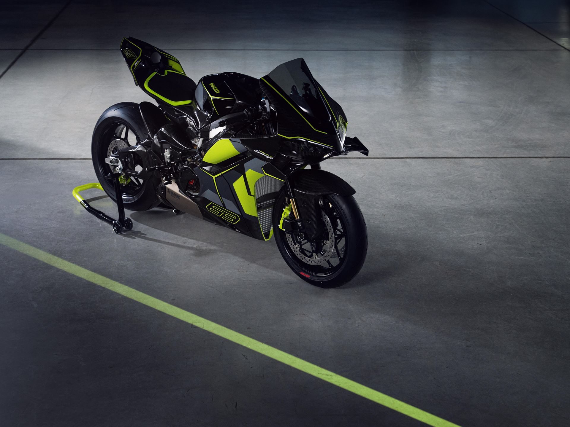 Ducati'S Panigale V4 Lamborghini Lets 63 Revuelto Owners Build A Matching Two-Wheel Garage 7 Ducati panigale v4 lamborghini on a stand in studio setting, showing dark grey bodywork with neon green accents and 63 branding