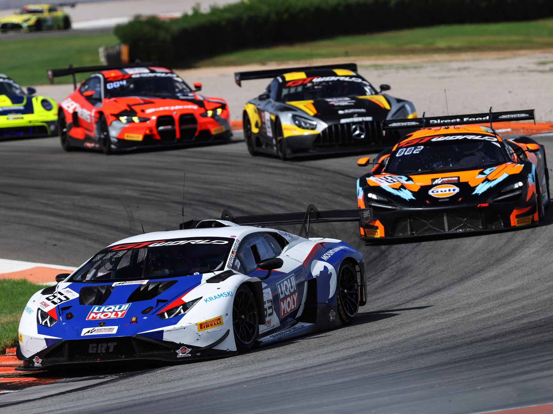 Huracán Gt3 Scores 197Th Win At Valencia As Lamborghini Prepares To Hand A Dynasty To The Temerario 5 Lamborghini huracán gt3 evo2 in white and blue livery leading a pack of gt race cars through a corner at valencia