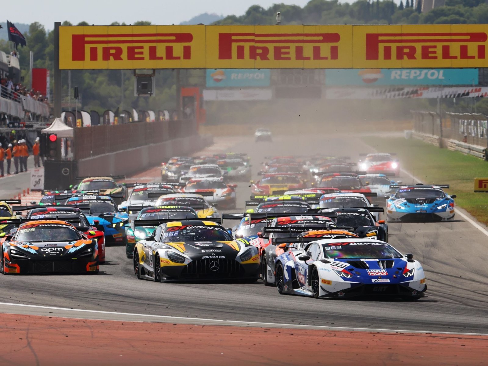Multiple GT3 race cars including a Lamborghini Huracán GT3 EVO2 at the start of a race at Valencia under a Pirelli banner
