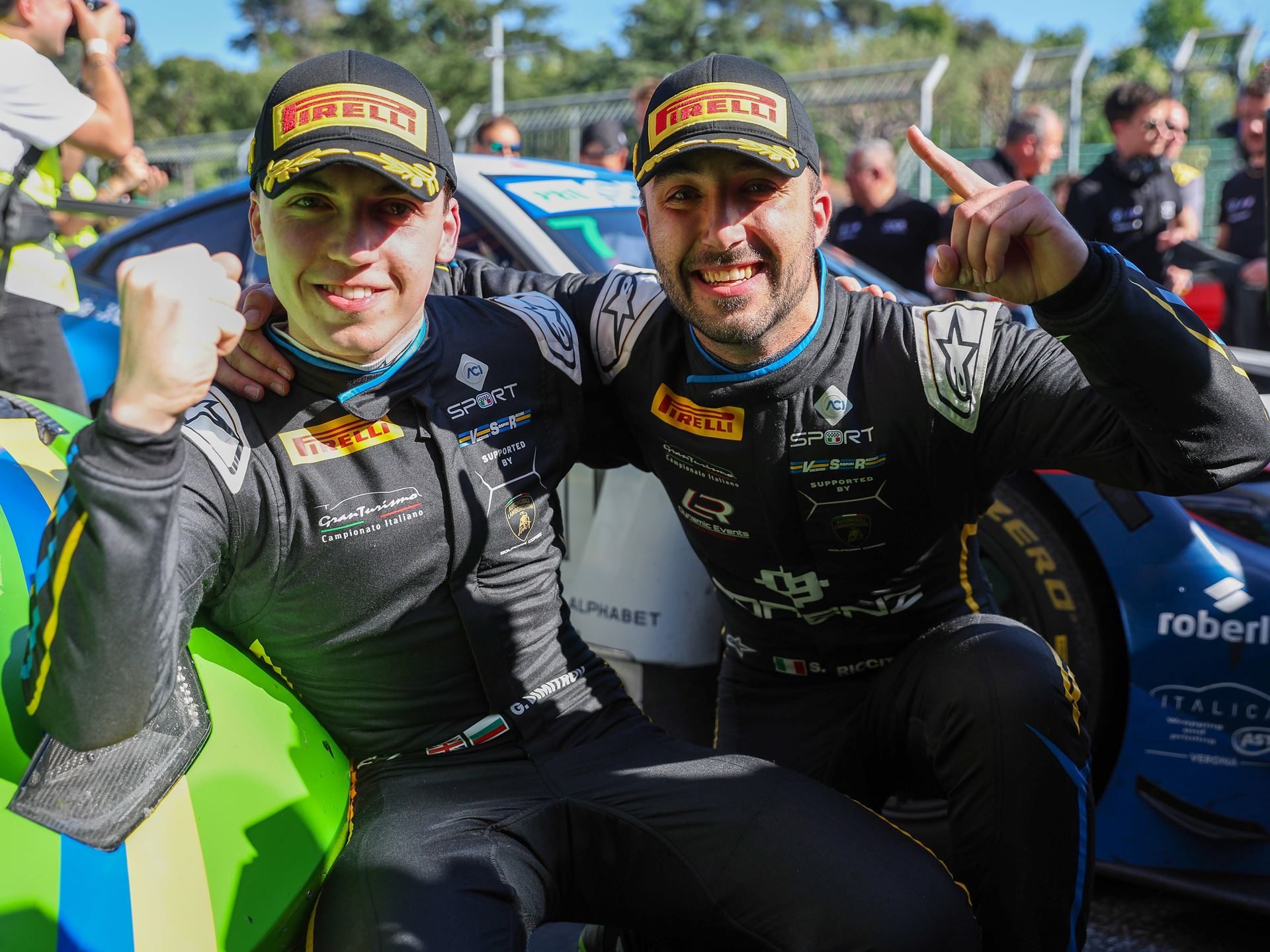 0.147 Seconds At Red Bull Ring: How The Huracán Gt3 Evo2 Opened Its Final Season With A Statement 11 Two lamborghini racing drivers in black racing suits and pirelli caps celebrating a victory