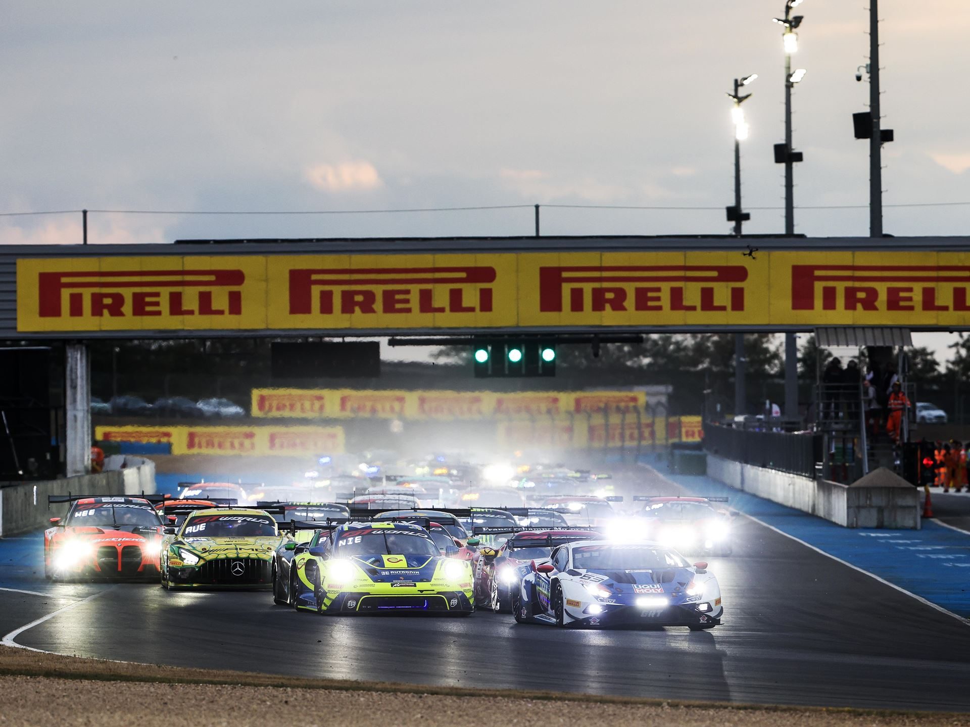The Huracán Gt3 Evo2'S Magny-Cours Victory Adds A Defining Chapter To Lamborghini'S V10 Racing Legacy 7 Multiple gt race cars including a lamborghini huracán gt3 evo2 lined up on the magny-cours circuit at dusk with headlights on