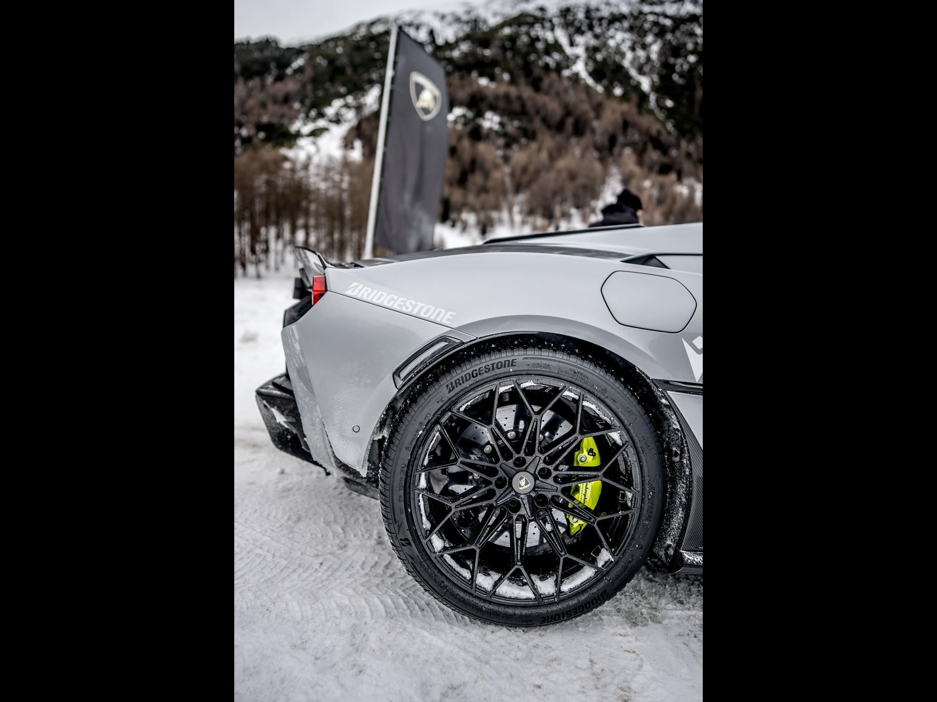 Accademia Neve 2026 Puts The Temerario On Ice, And Lamborghini'S Experiential Edge Over Rivals On Full Display 9 Close-up of rear wheel and fender of grey lamborghini huracán showing bridgestone branding and green brake caliper