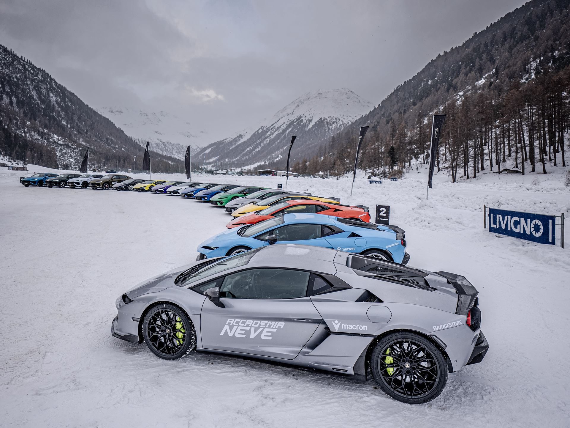 Accademia Neve 2026 Puts The Temerario On Ice, And Lamborghini'S Experiential Edge Over Rivals On Full Display 11 Line of colorful lamborghini huracáns branded for accademia neve parked in snowy livigno mountain valley