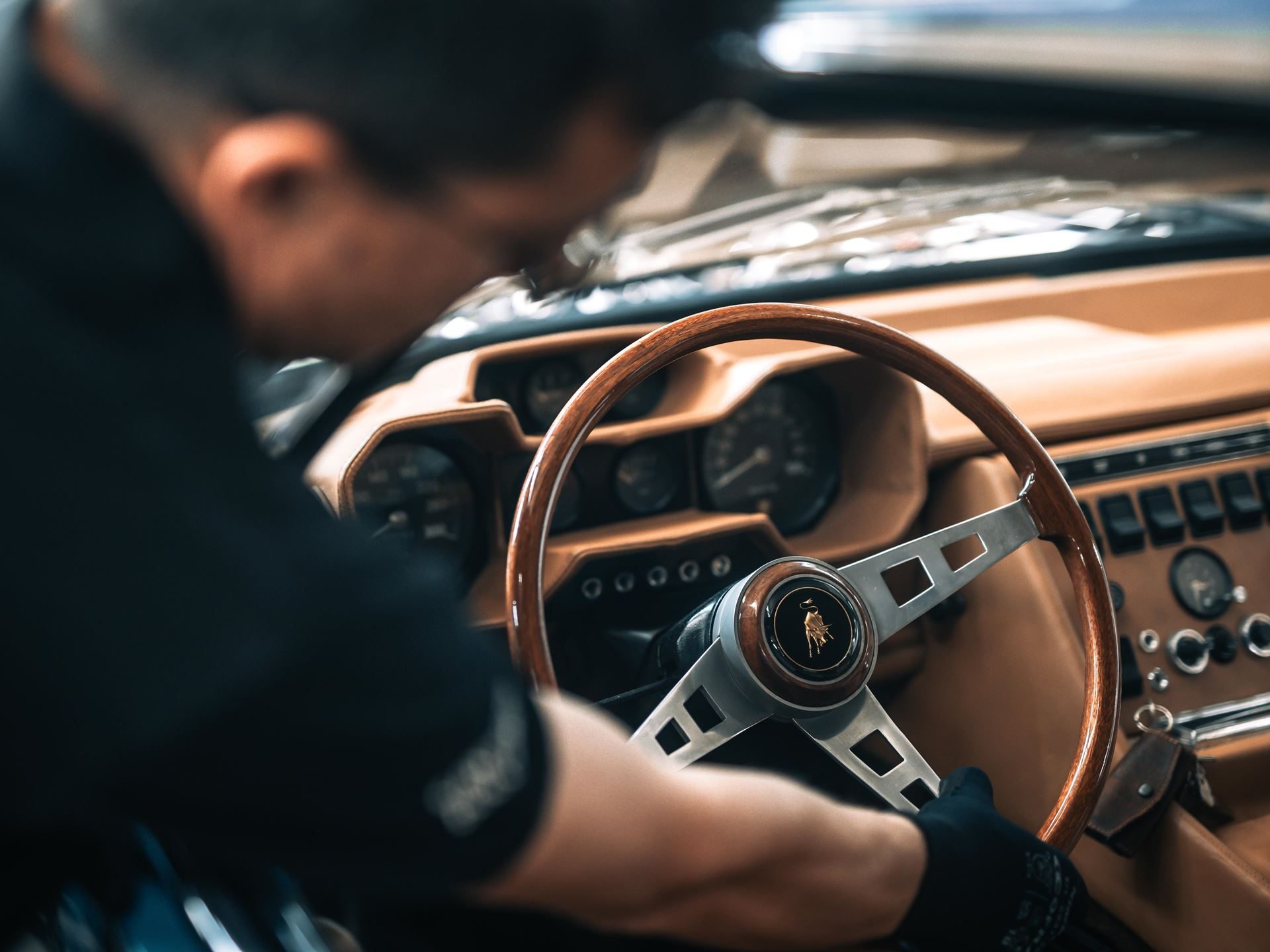 Five Years Of Free Maintenance And A Decade Of Warranty: What Lamborghini'S Expanded Aftersales Program Actually Covers 3 A technician in black gloves carefully works on the wooden steering wheel and tan leather interior of a classic lamborghini miura during a polo storico restoration
