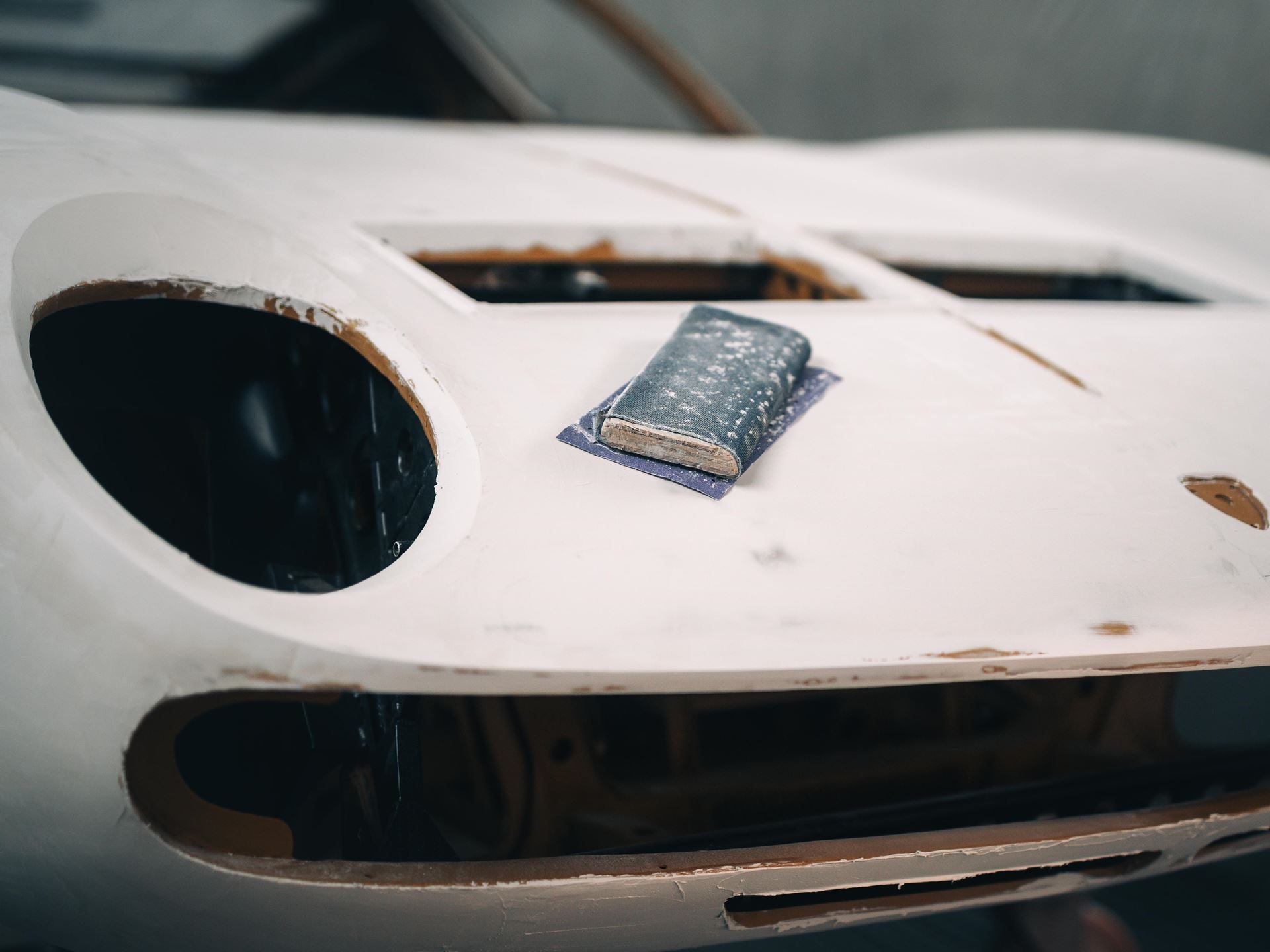 Five Years Of Free Maintenance And A Decade Of Warranty: What Lamborghini'S Expanded Aftersales Program Actually Covers 5 A sanding block rests on the front hood of a classic lamborghini miura in primer, showing meticulous bodywork preparation during a polo storico restoration