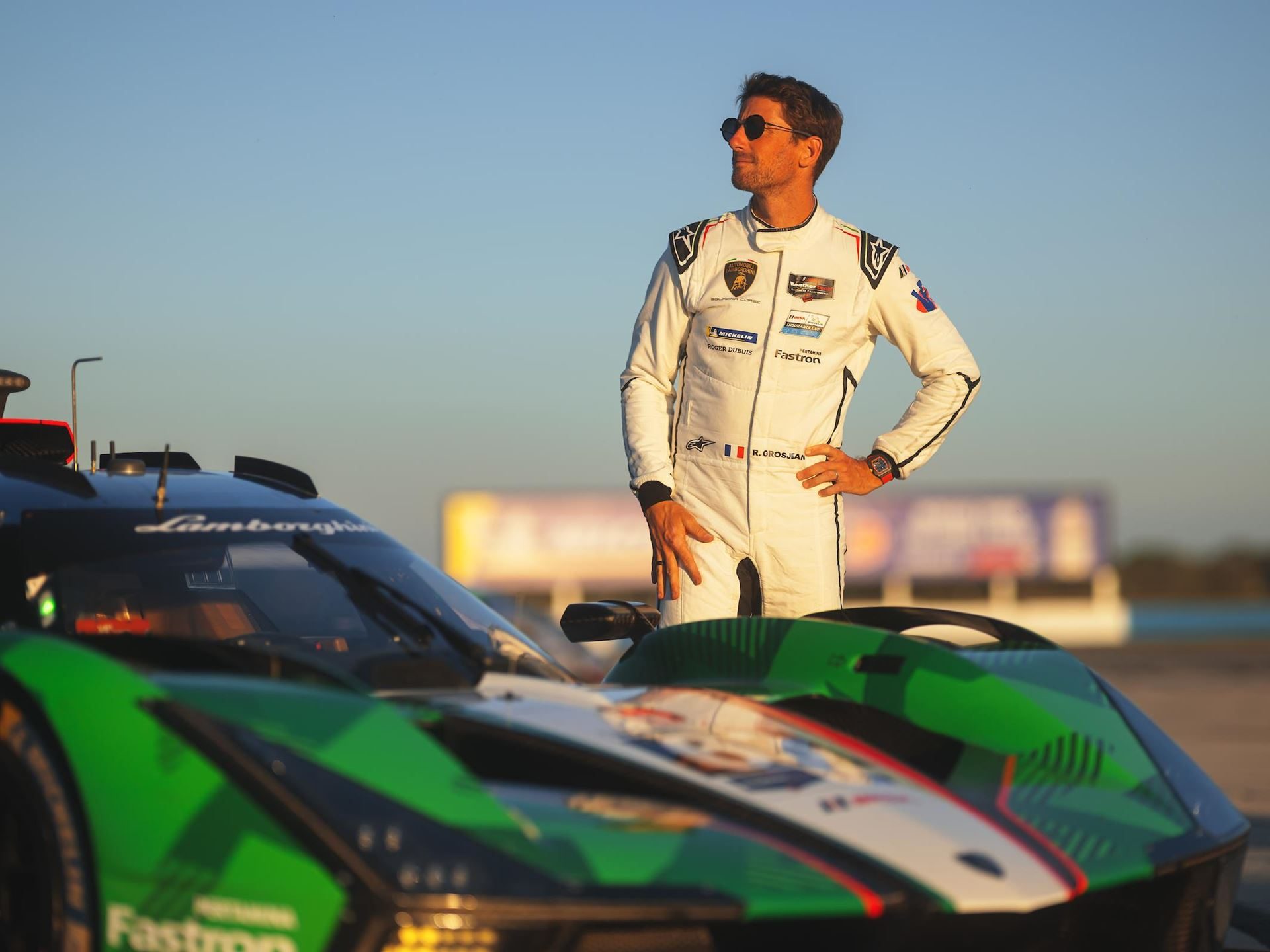 Alpinestars Will Suit Up Lamborghini'S Entire Racing Operation, From Super Trofeo To Lmdh 3 Lamborghini factory driver in white alpinestars racing suit standing beside the sc63 lmdh car