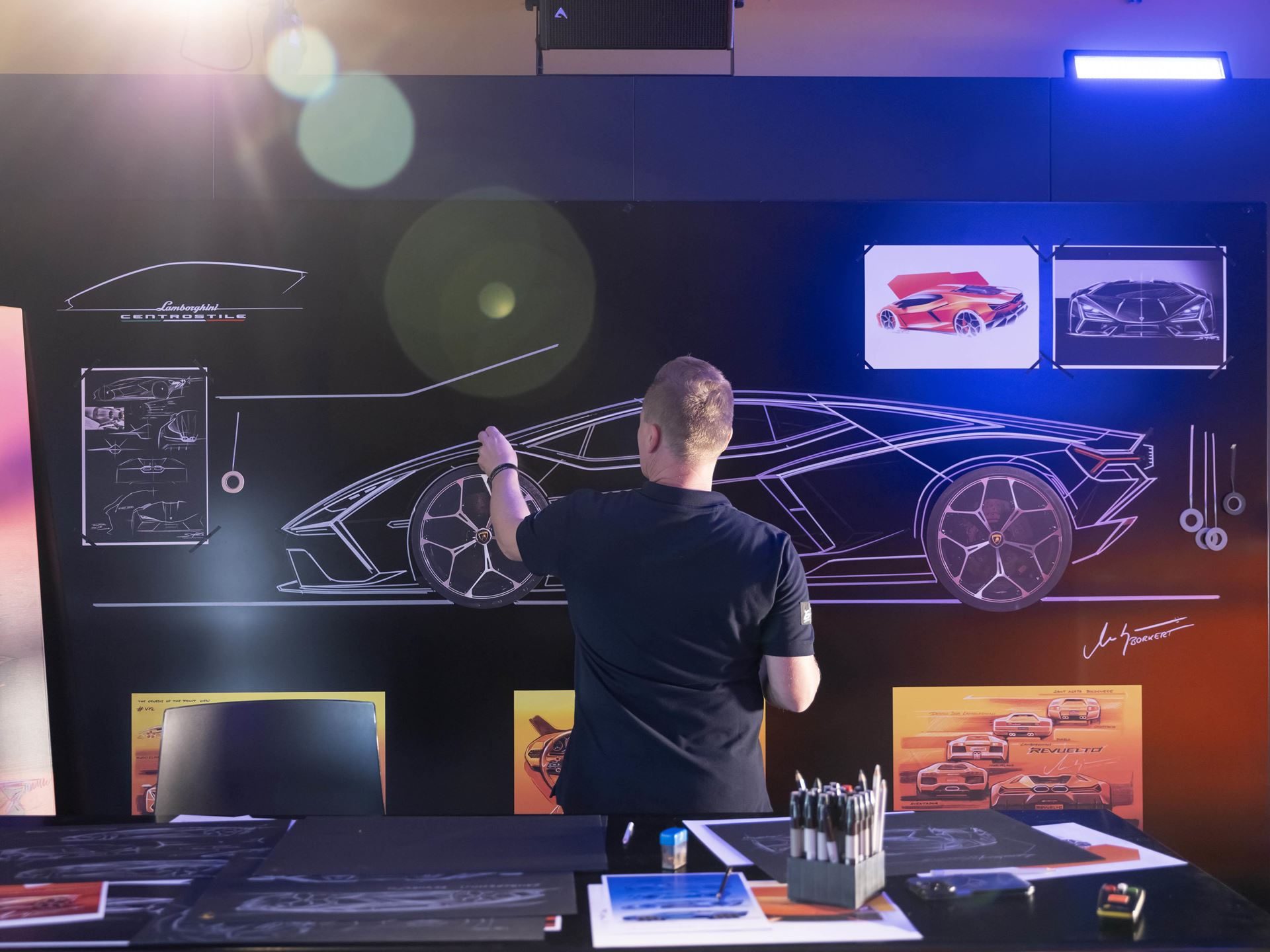 How One Decision In 2003 Gave Lamborghini Total Control Over Its Design Destiny 9 A centro stile designer sketching the side profile of the lamborghini revuelto on a large black board with smaller concept images visible