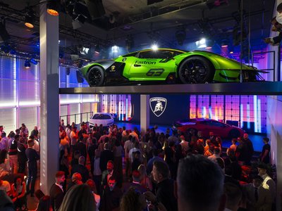 Lamborghini Day Germany 2025 Puts The Fully Electrified Lineup On Display In Munich 2 Indoor display at lamborghini day germany 2025 showing a green essenza scv12 on an elevated platform alongside a white revuelto and a crowd of guests