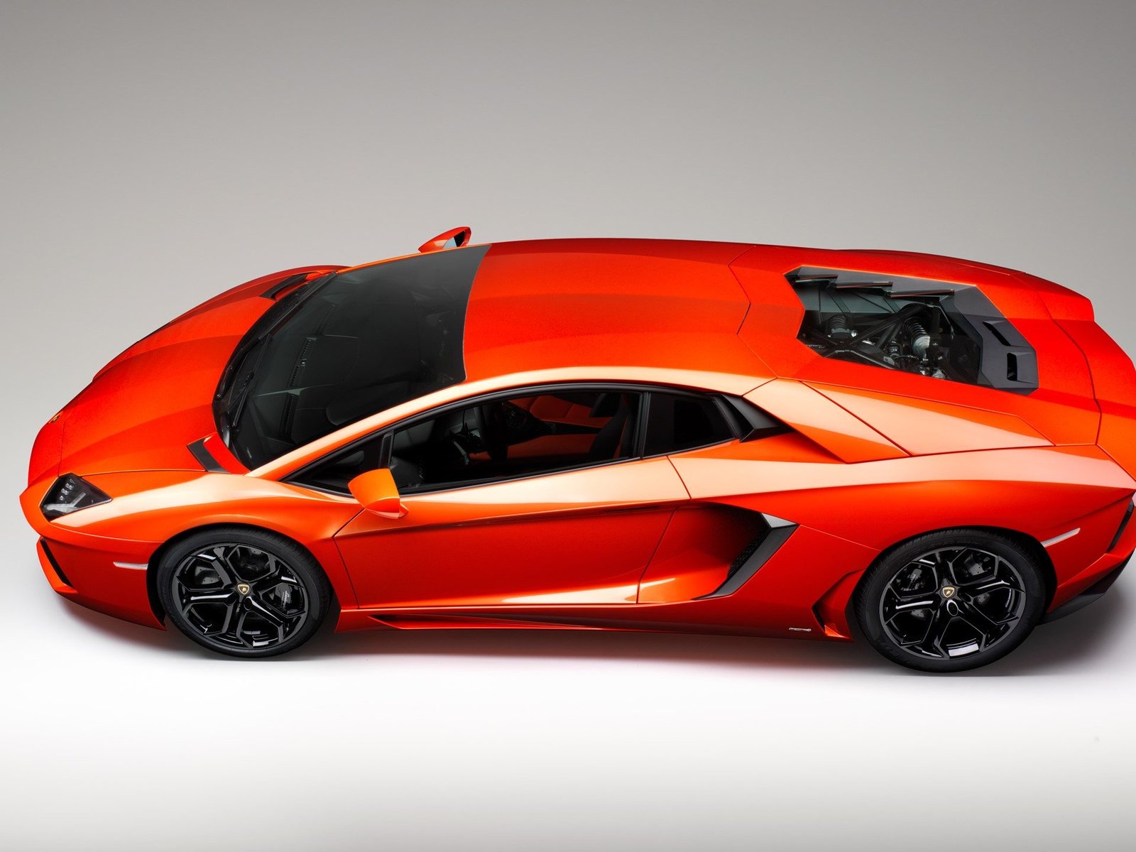 Orange Lamborghini Aventador LP 700-4 studio shot showcasing aggressive angular bodywork and mid-engine layout