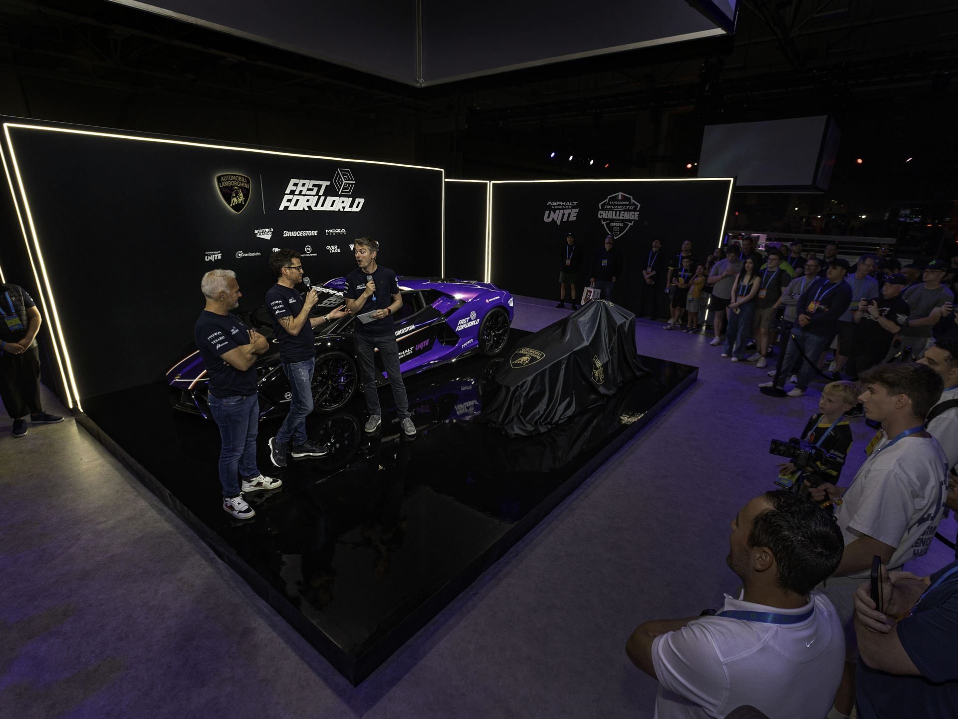 Lamborghini Crashed A Gaming Festival With A 1015 Hp Revuelto, Racing Simulators, And A Plan To Win Over A New Generation 7 Wide shot of lamborghini's dreamhack dallas presentation stage featuring a lamborghini on stage, speakers, and an engaged audience
