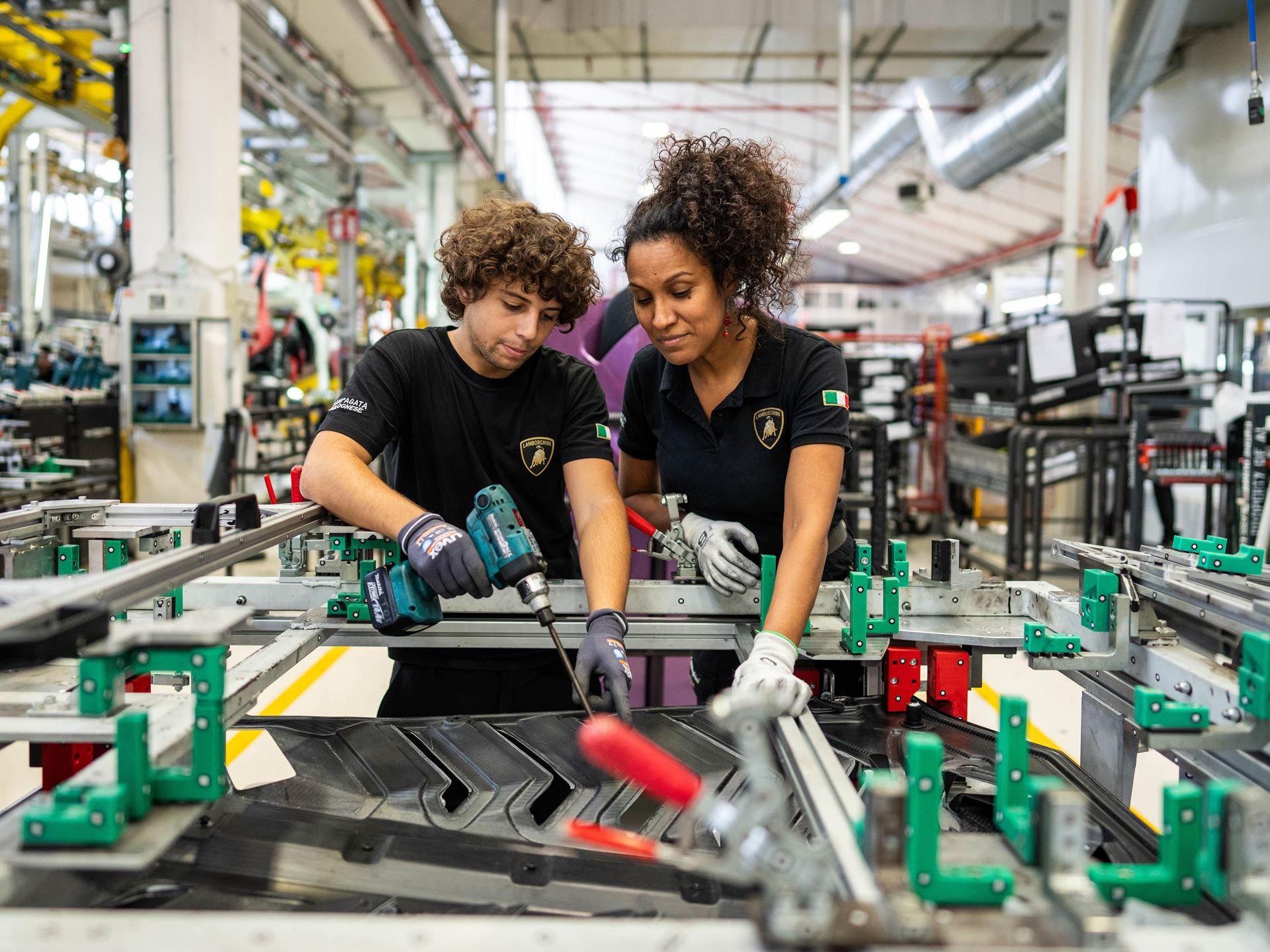 Italy'S Most Desired Employer Builds Supercars: What Lamborghini'S 79.8% Approval Rating Really Means 5 Two lamborghini factory workers in branded black t-shirts collaborating on an assembly line task