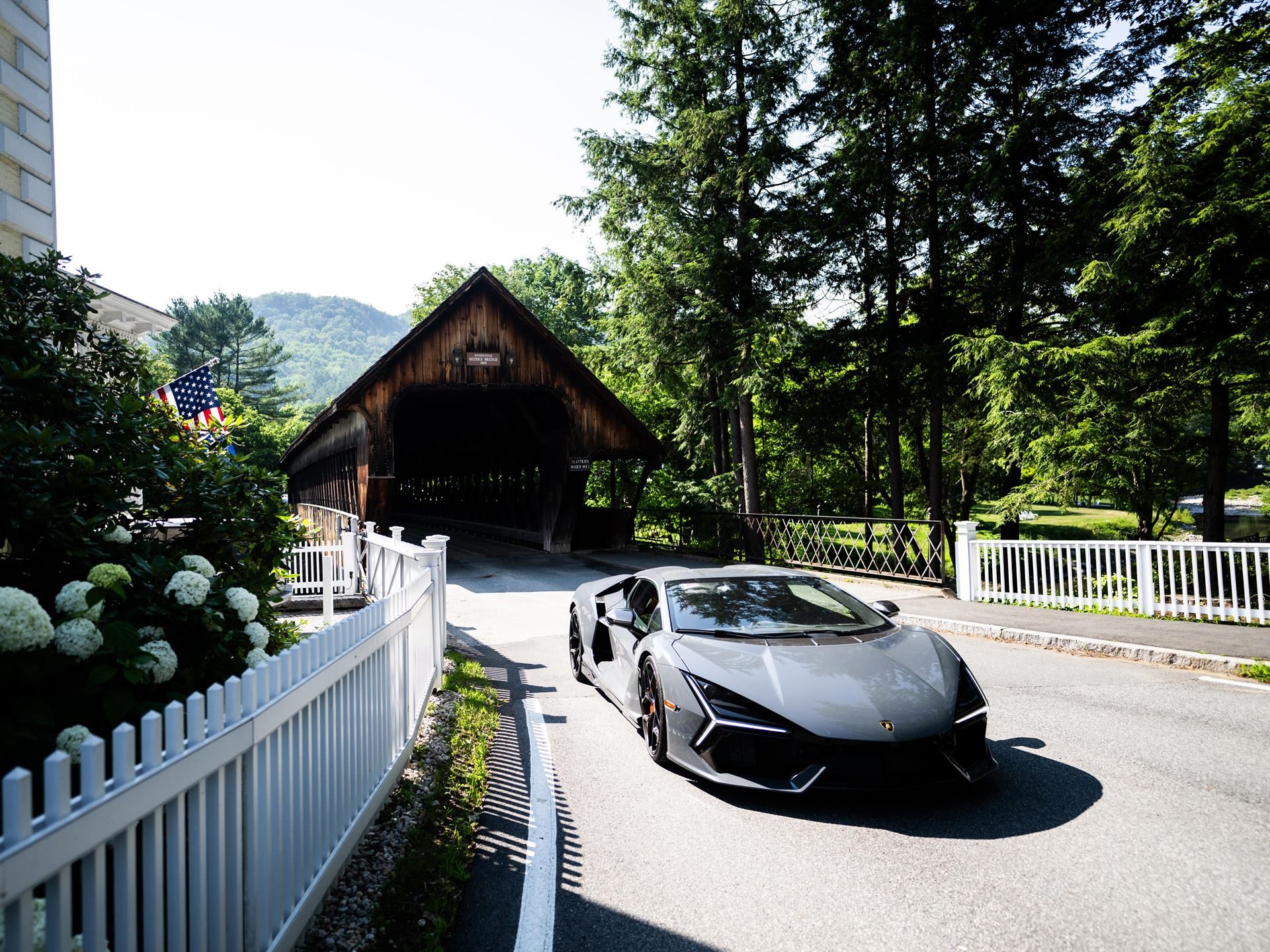 449 Miles Of New England Back Roads With 30 Lamborghinis: Inside The Esperienza Giro Usa 5 A grey lamborghini revuelto drives past a traditional new england covered bridge