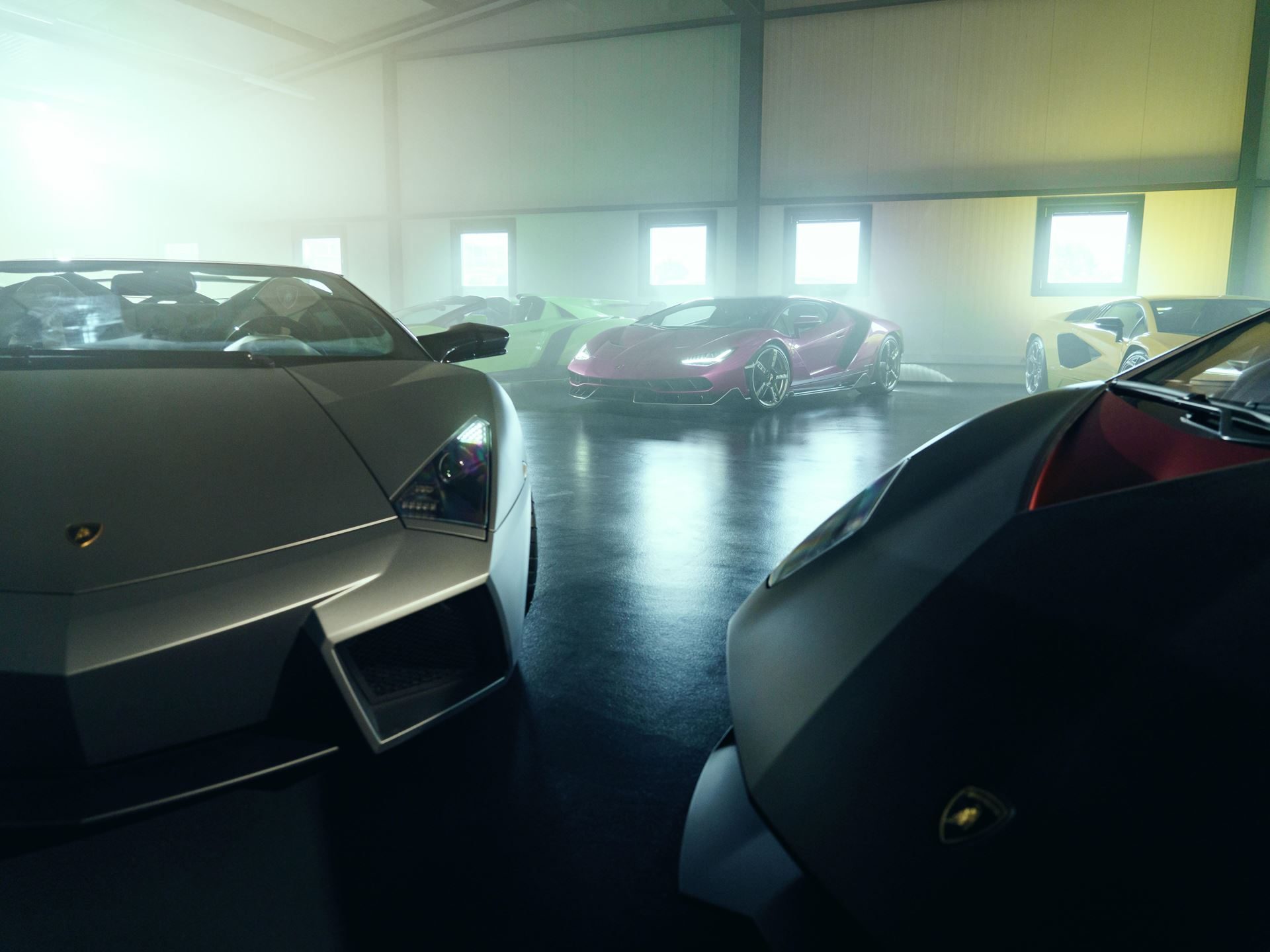 Collection of lamborghini limited-edition roadsters including the veneno, centenario, and sián displayed in a misty, dramatically lit studio