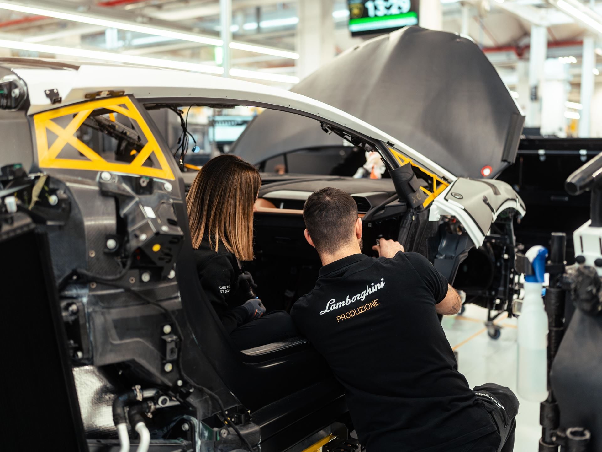Lamborghini'S First Sustainability Report Reveals A Paradox: Emissions Rose While Every Car Went Hybrid 5 Two factory workers assembling the interior of a lamborghini urus on the production line at sant'agata bolognese