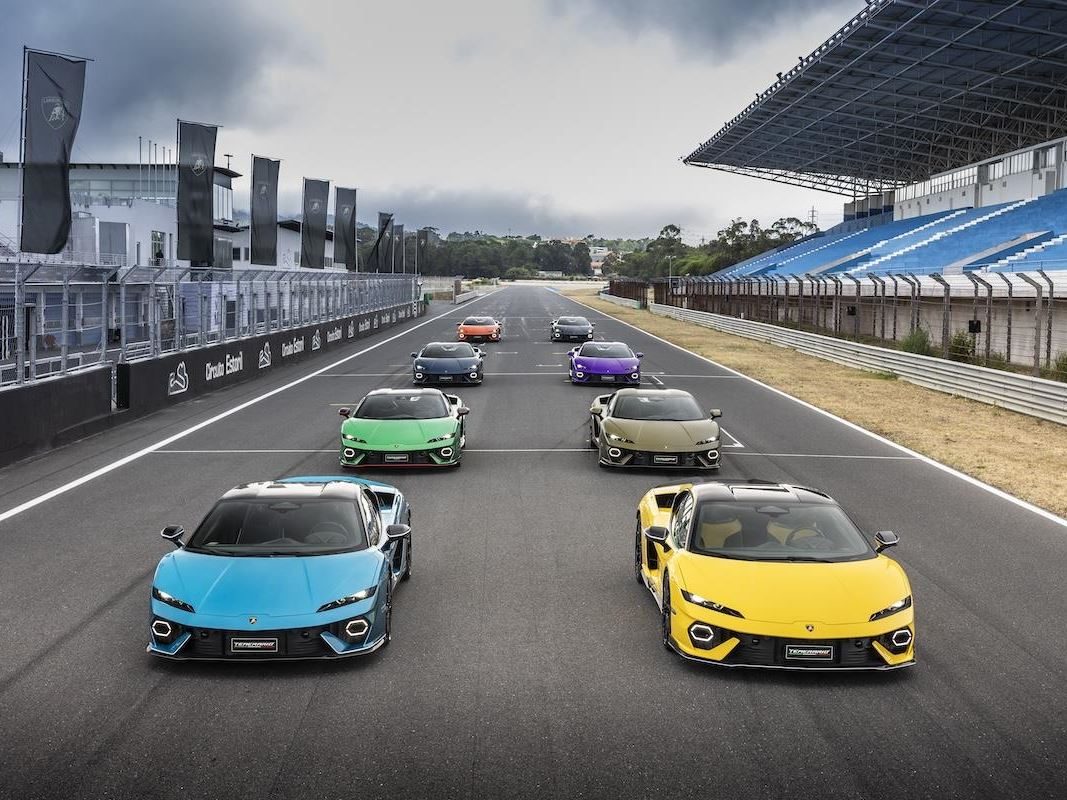 Lamborghini'S Hybrid Bet Pays Off: Record Deliveries, A Killed Ev, And 26.6% Margins Tell The Real Story 5 Multiple lamborghini revuelto models in various colors lined up on a race track with grandstand in background