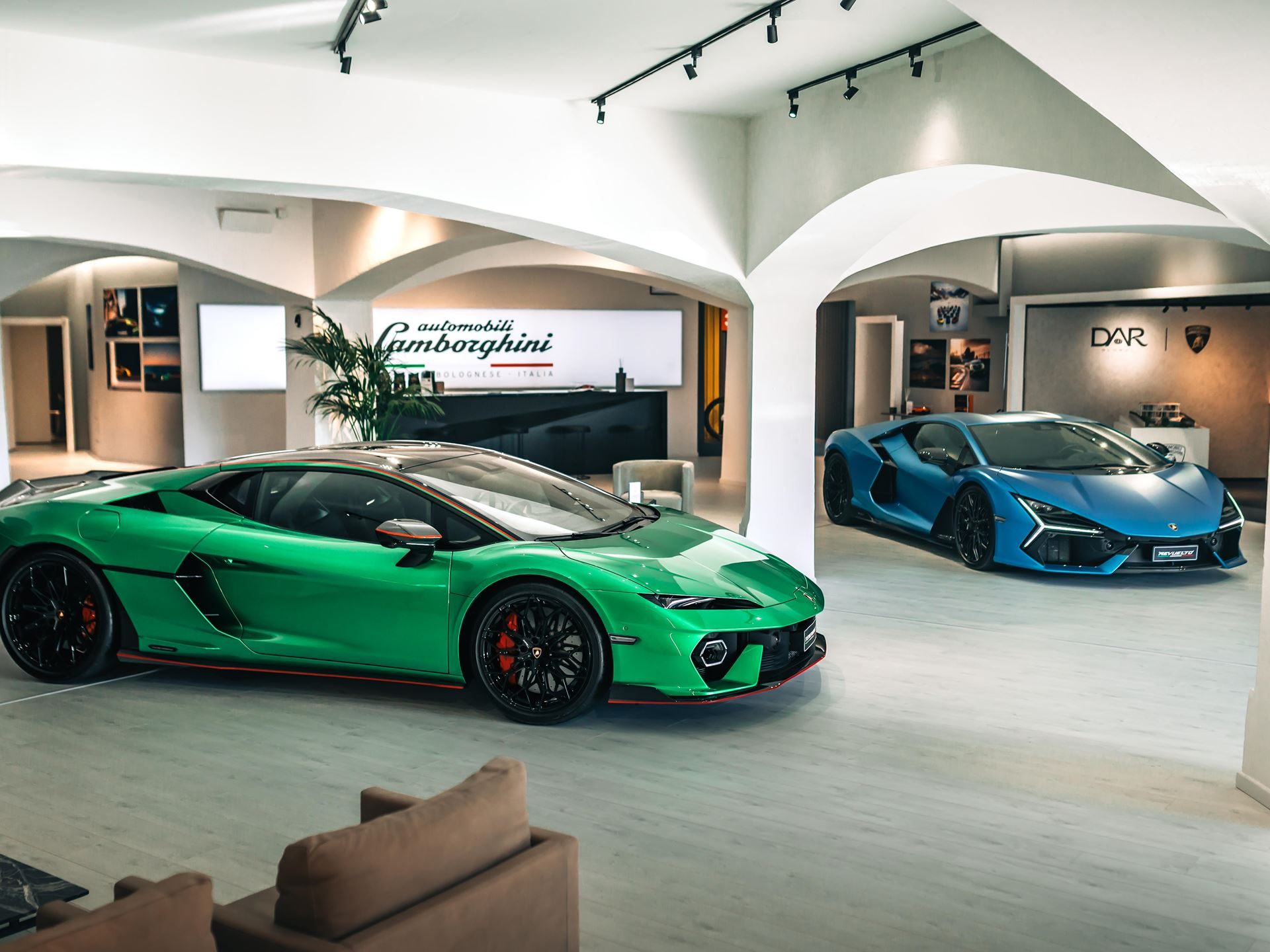 Lamborghini'S Porto Cervo Lounge Returns For A Seventh Summer, Now Showcasing An All-Hybrid Lineup 3 Two lamborghini supercars displayed in the porto cervo lounge showroom with the automobili lamborghini logo visible