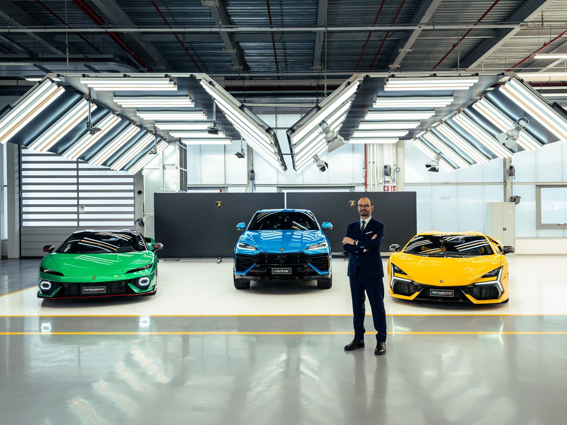 Lamborghini'S New 'Alternative Fuels' Role Signals What Comes After Hybridization 9 Stephan winkelmann standing in front of a green huracán sto, blue urus, and yellow revuelto